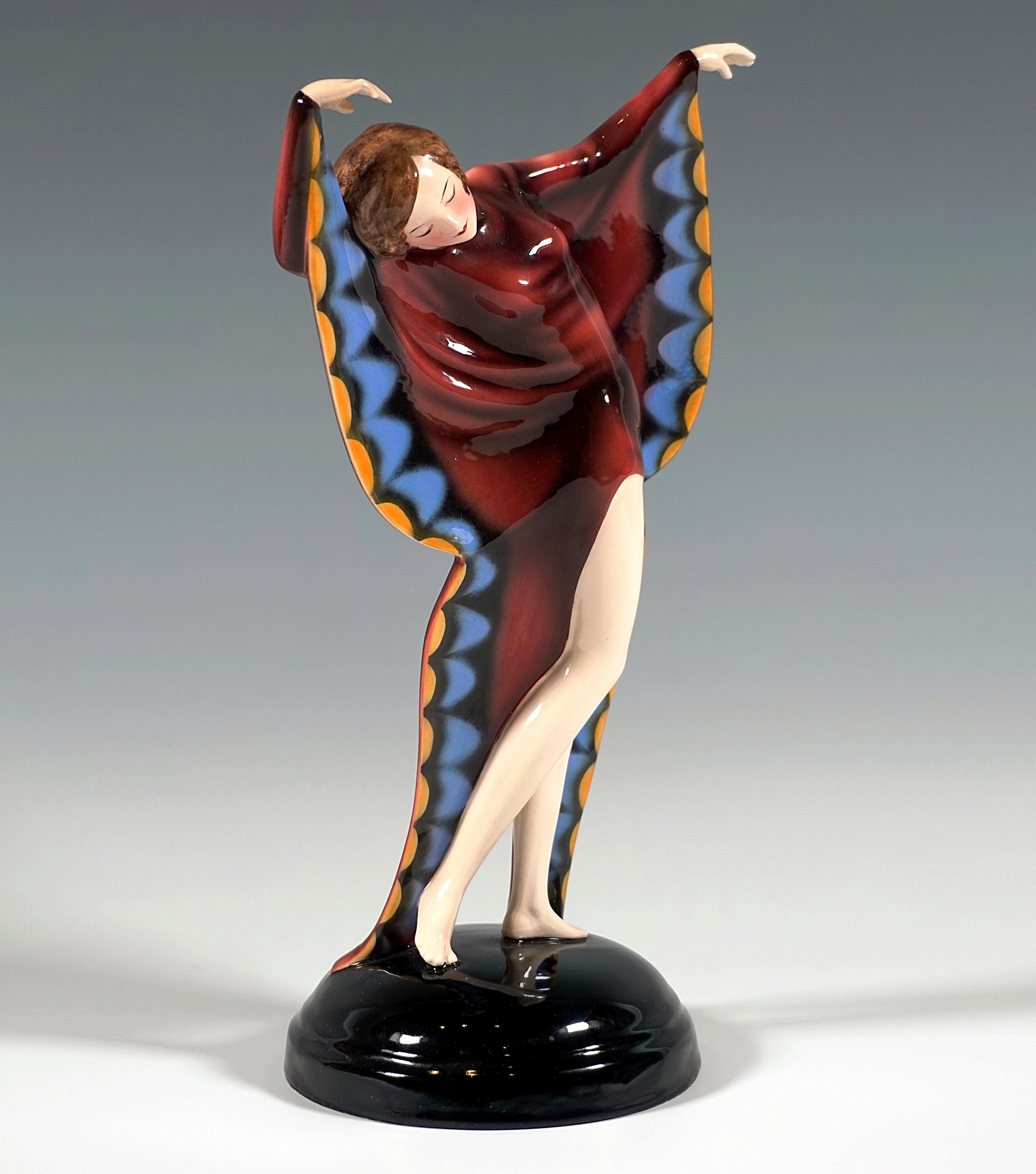 Très rare figurine en céramique vers 1930 :
Jeune danseuse gracieuse en costume de papillon, posant : les bras levés et la tête inclinée sur le côté, effectuant un léger mouvement de rotation, le tissu tombant de ses manches décoré à la manière d'un