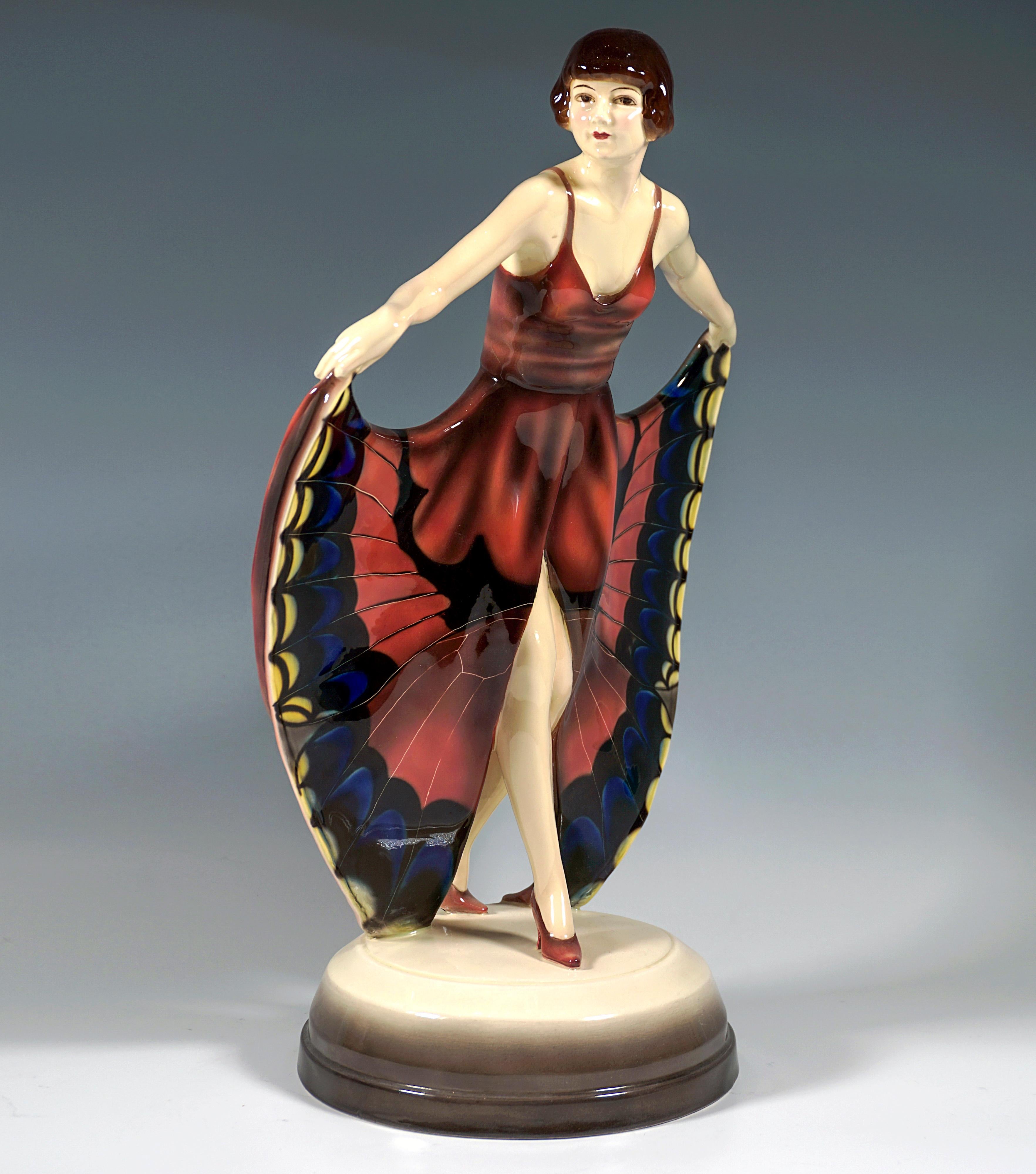 Rare Goldscheider Art Deco ceramic figure of the 1920's: 
Young dancer with pageboy hairstyle, leaning slightly forward and looking to the right, putting her right leg forward and holding the high slit skirt with butterfly decoration like wings with