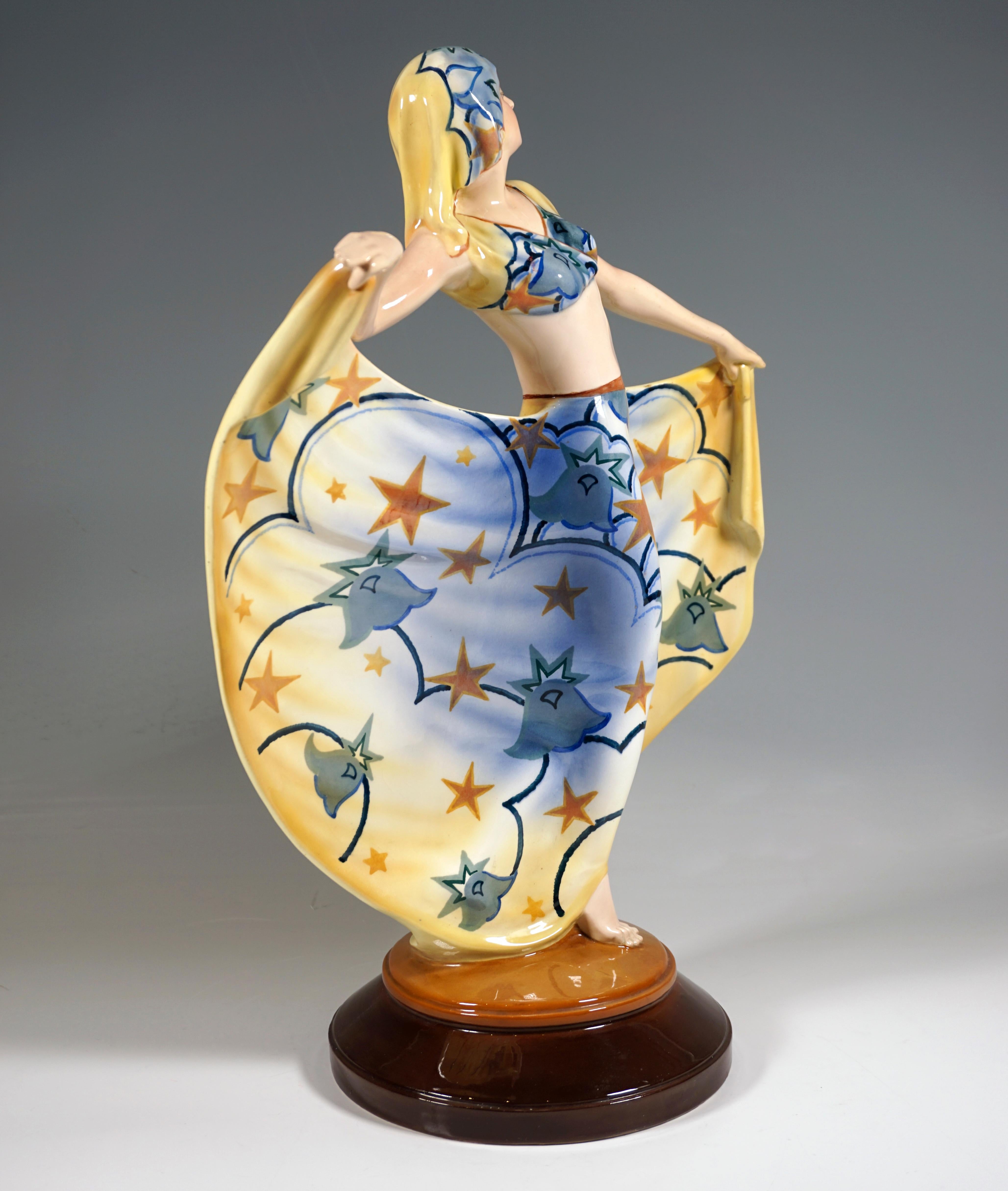 Rare Goldscheider Art Deco ceramic figure of the 1920's: 
Posing dancer in oriental costume: cropped, short-sleeved top, floor-length, wide skirt and headgear, all clothing with the same decoration - stars and stylized flowers in front of