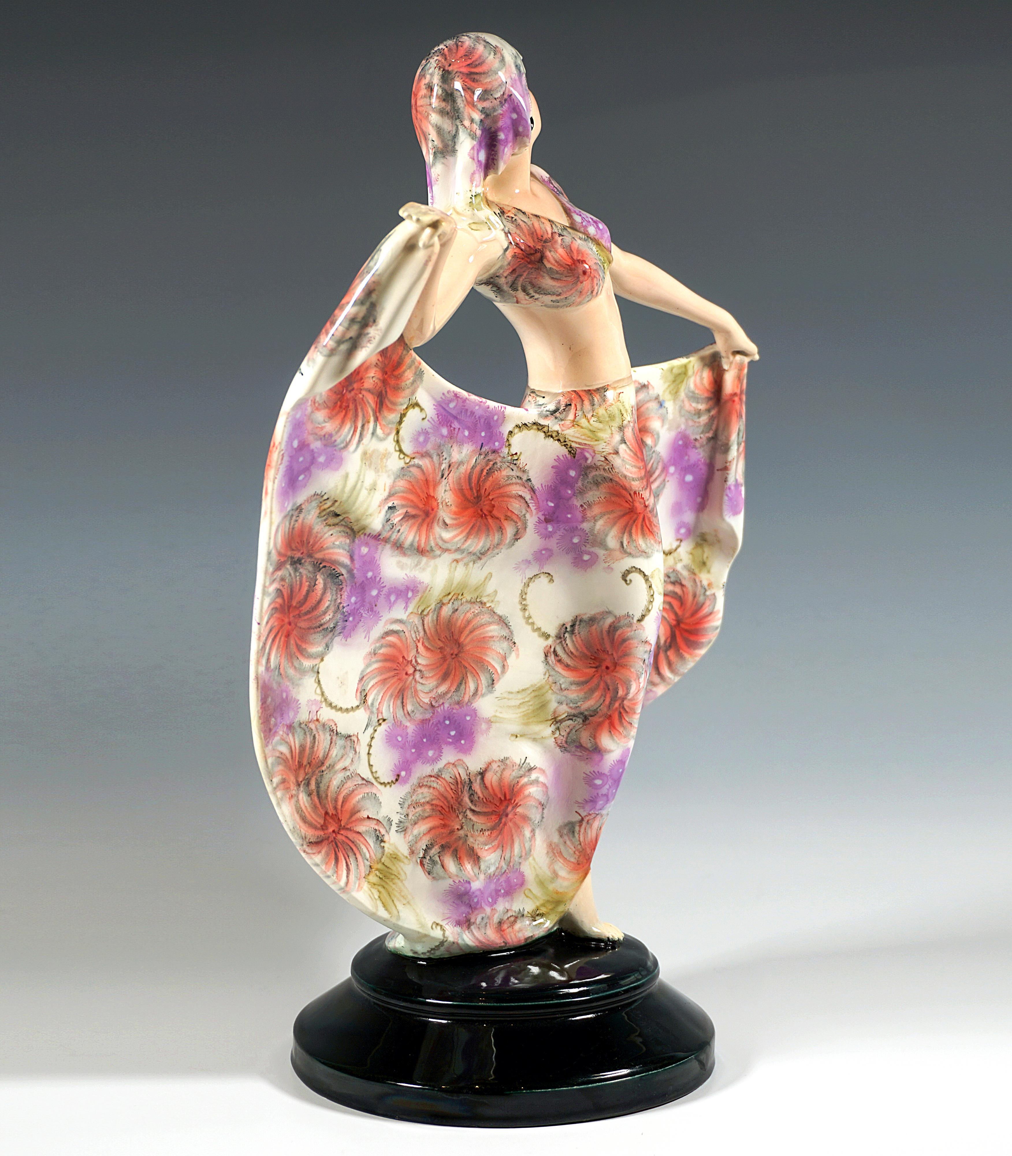 Rare figurine en céramique Goldscheider Art Deco des années 1920 : 
Une gracieuse danseuse en costume oriental : haut à manches courtes et sans ventre, jupe large et longue et foulard jouant autour du visage peint de manière expressive, toutes les