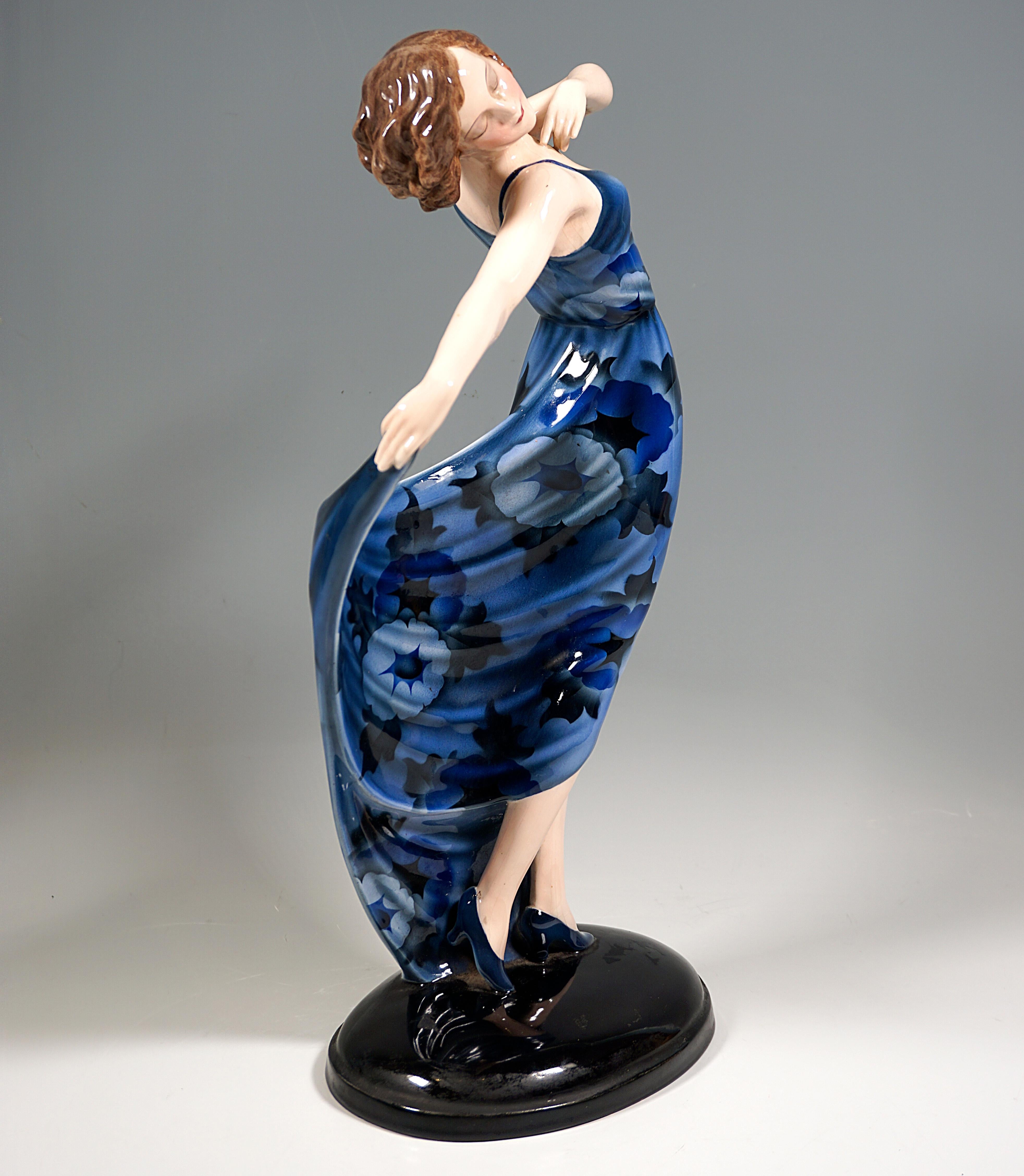 Elegant Goldscheider Art Deco Ceramic Figure Around 1930: 
Extremely rare model of a dancer with chin-length, brunette hair in a blue, long dance dress with abstract, floral decoration, posing with the upper body slightly turned to the side and