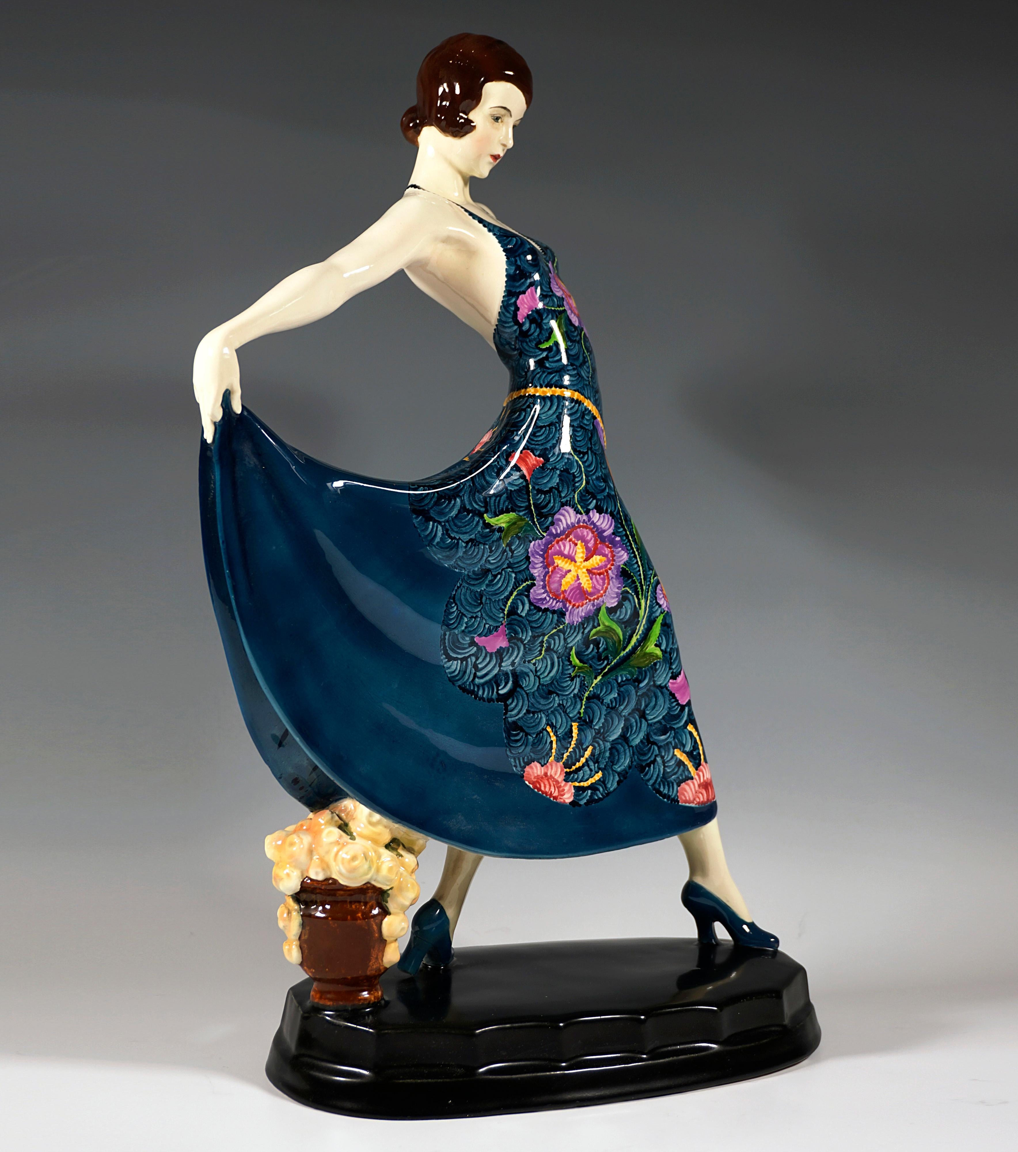 Rare Goldscheider Art Ceramic Figurine Of The 1920s:
Depiction of the actress and dancer Lilian Harvey wearing a dark wig and striding in a long, at the back low-cut dress decorated with an elaborate floral pattern, holding her skirt up behind her