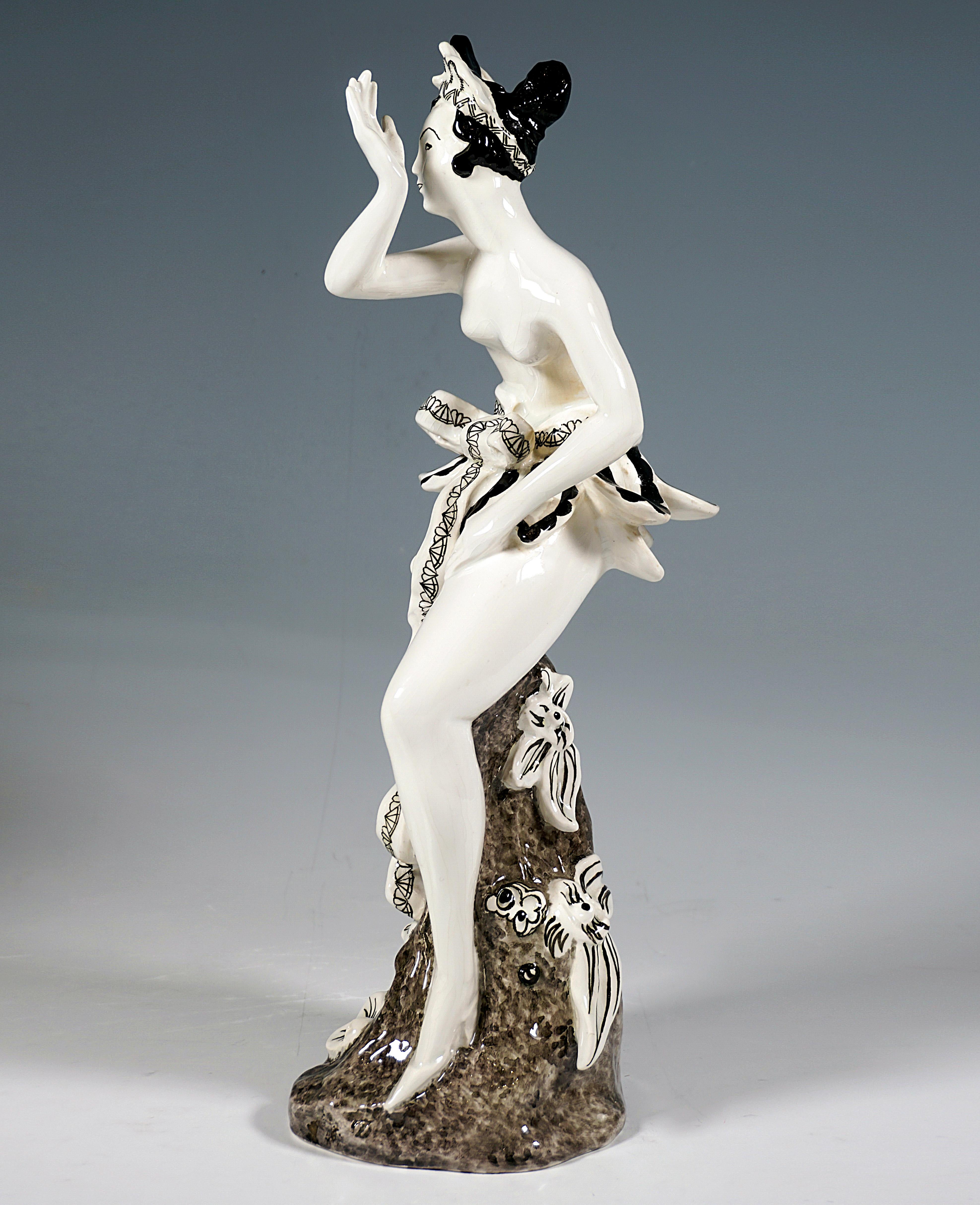 Beeindruckende Goldscheider Wiener Keramikfigur aus den 1920er Jahren:
Die junge Dame mit kunstvoll hochgestecktem Haar und Kopfschmuck trägt nur einen exotisch anmutenden kurzen Rock in der Art einer Reihe abstehender Blütenblätter, der mit einer