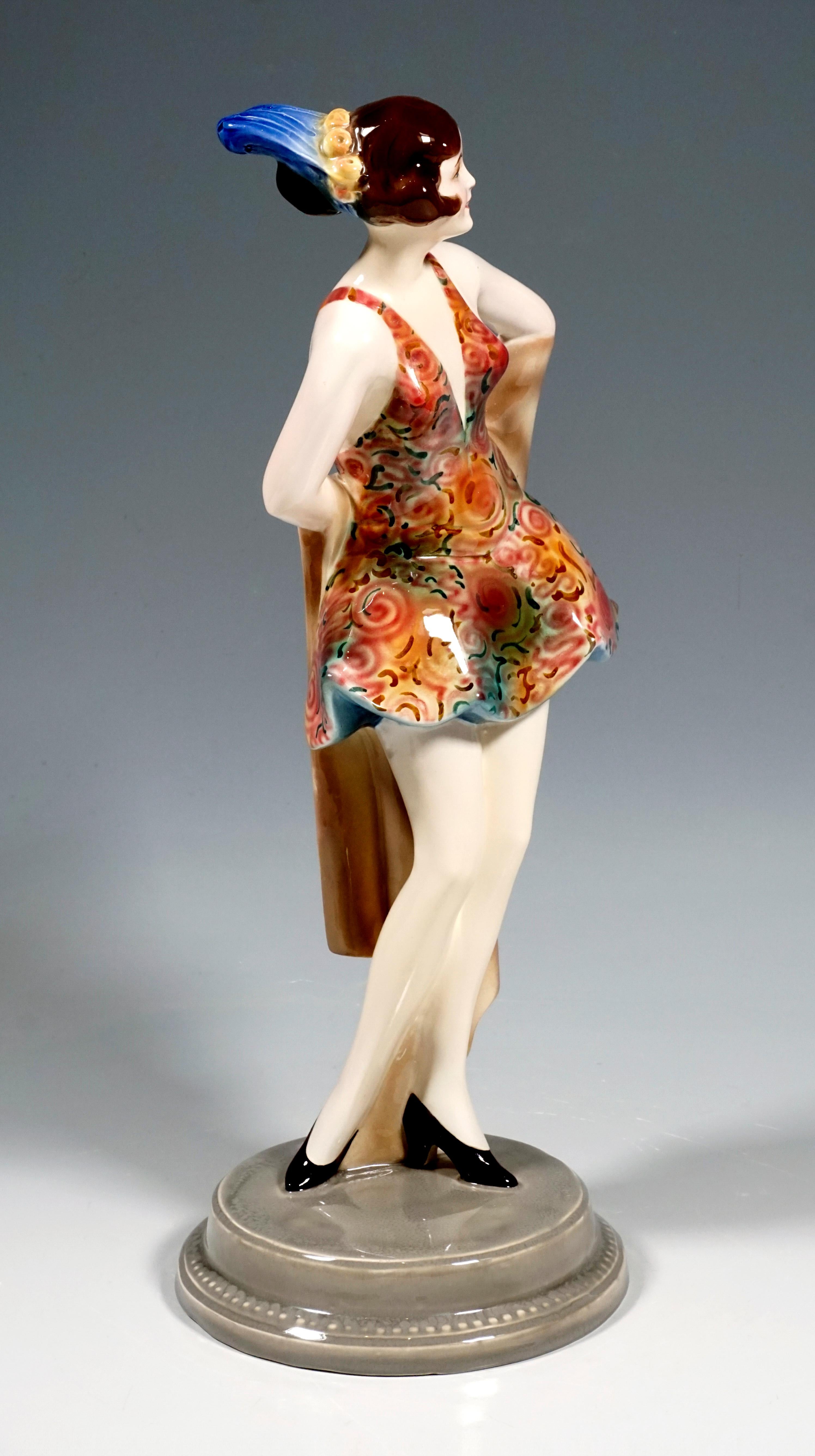 Rare Art Déco Goldscheider Ceramics figurine
The dancer wears a dance dress in red-brown tones cut low at the front and back with a wide, short skirt, with a pattern of stylized flowers. Her brown hair is pinned up with a flower ring and feather