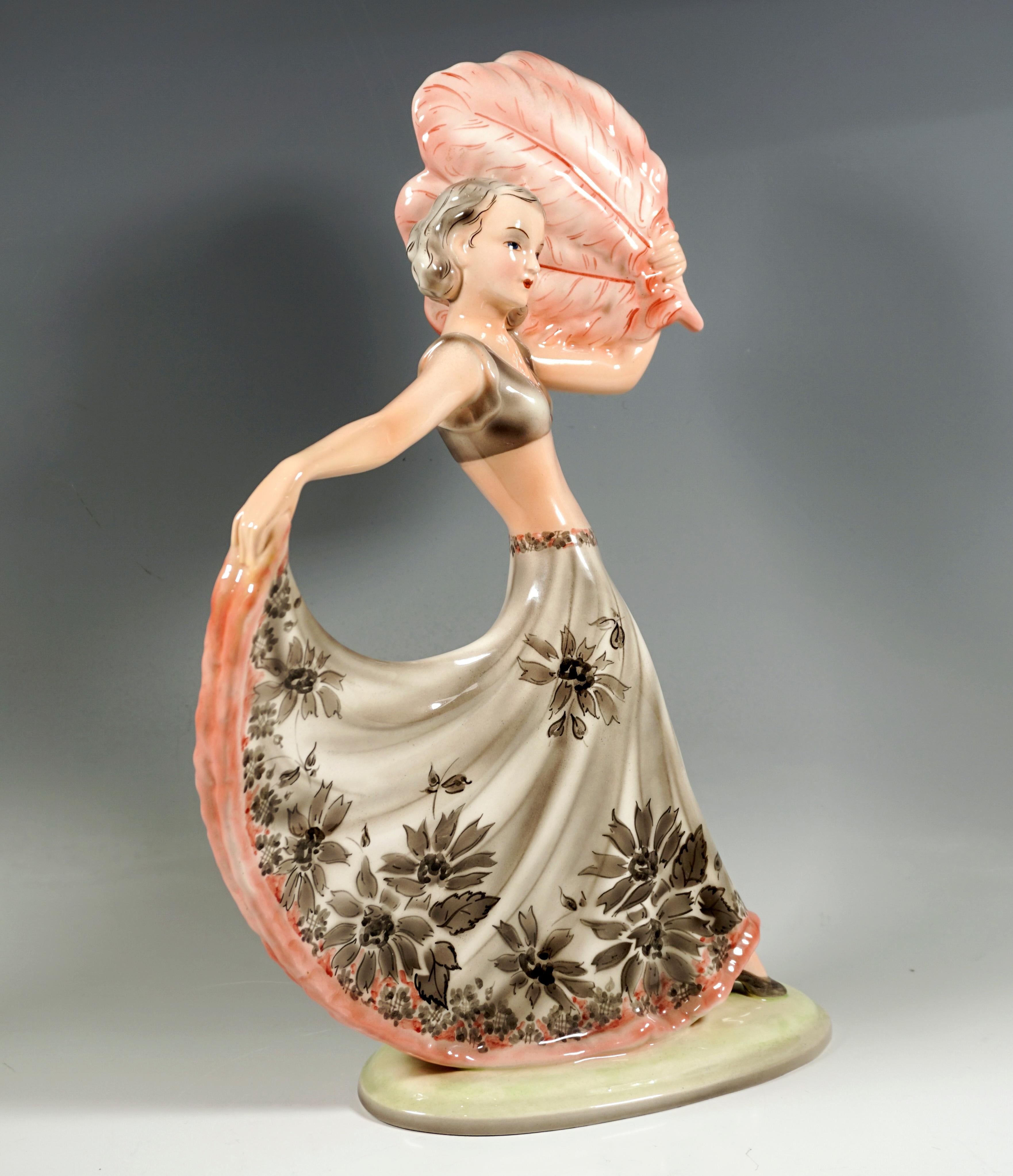 Elegant Goldscheider Art Deco ceramic figure of the 1930's: 
Dancer with shoulder-length hair in a long, wide, light gray skirt with floral decoration and a pink hem and matching bustier, looking to the right, leading her right leg forward and with