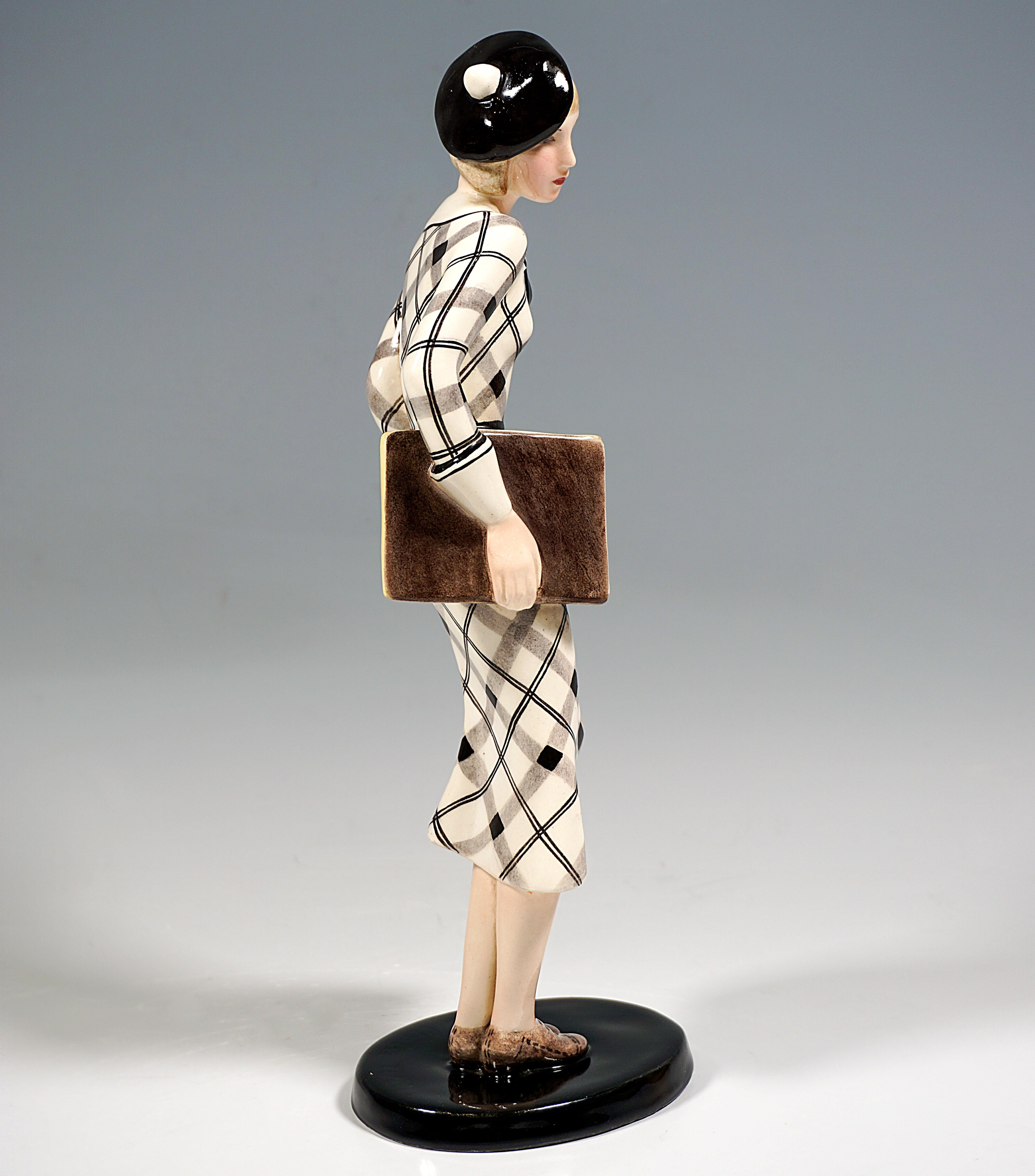 Very Rare Goldscheider Vienna Ceramic Figure of the 1930s:
Standing young lady with a black beret cap on her blond, chin-length hair, in a long white-gray-black checkered dress with white cuffs and collar with a black bow and laced college shoes,