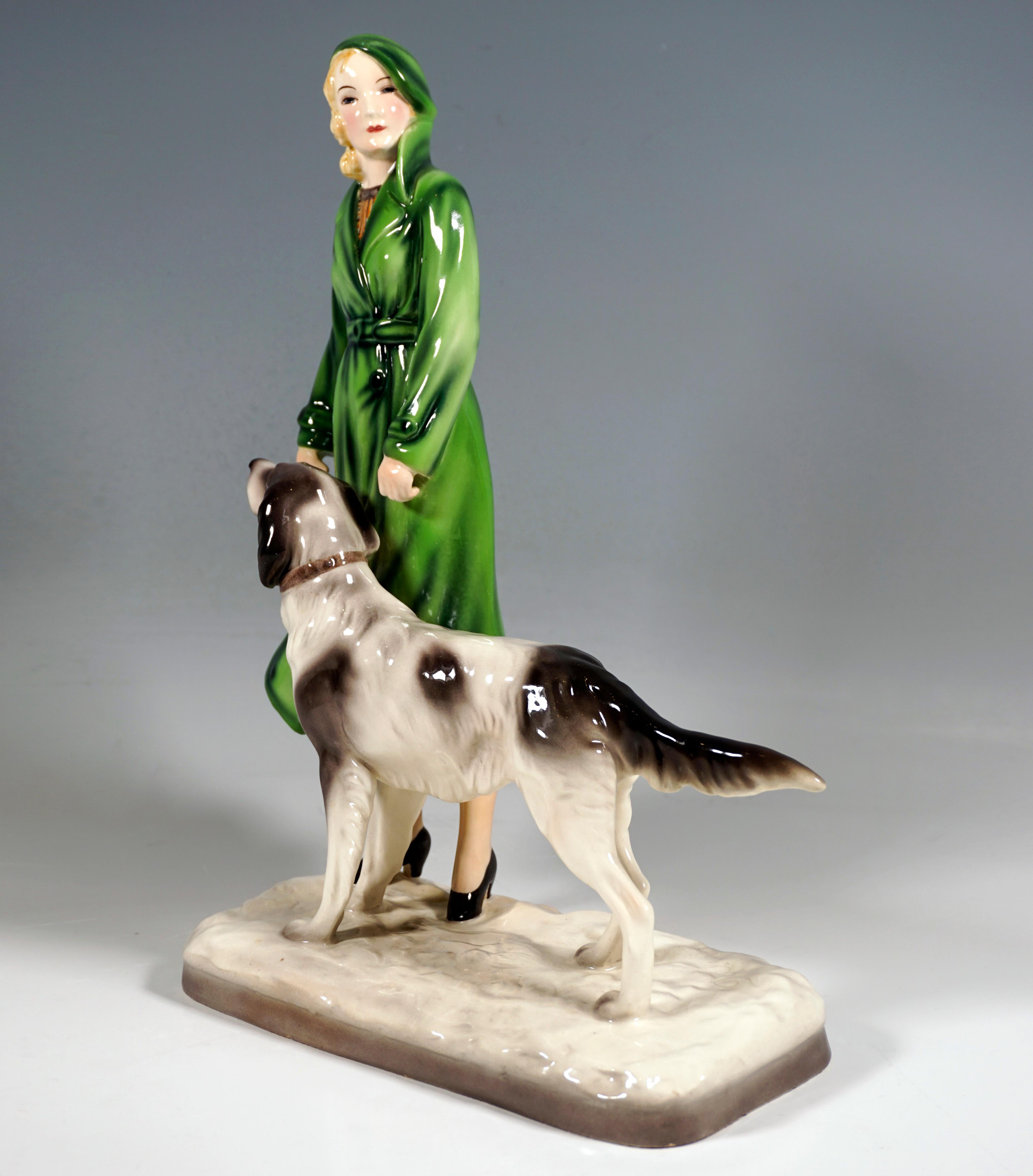 Very Rare Goldscheider Vienna ceramic Figurine of the 1930s:
Standing blond lady with cap and coat, showing great resemblance to Marlene Dietrich, with setter.
On a cream-colored rectangular base with rounded corners and an uneven surface, shaded