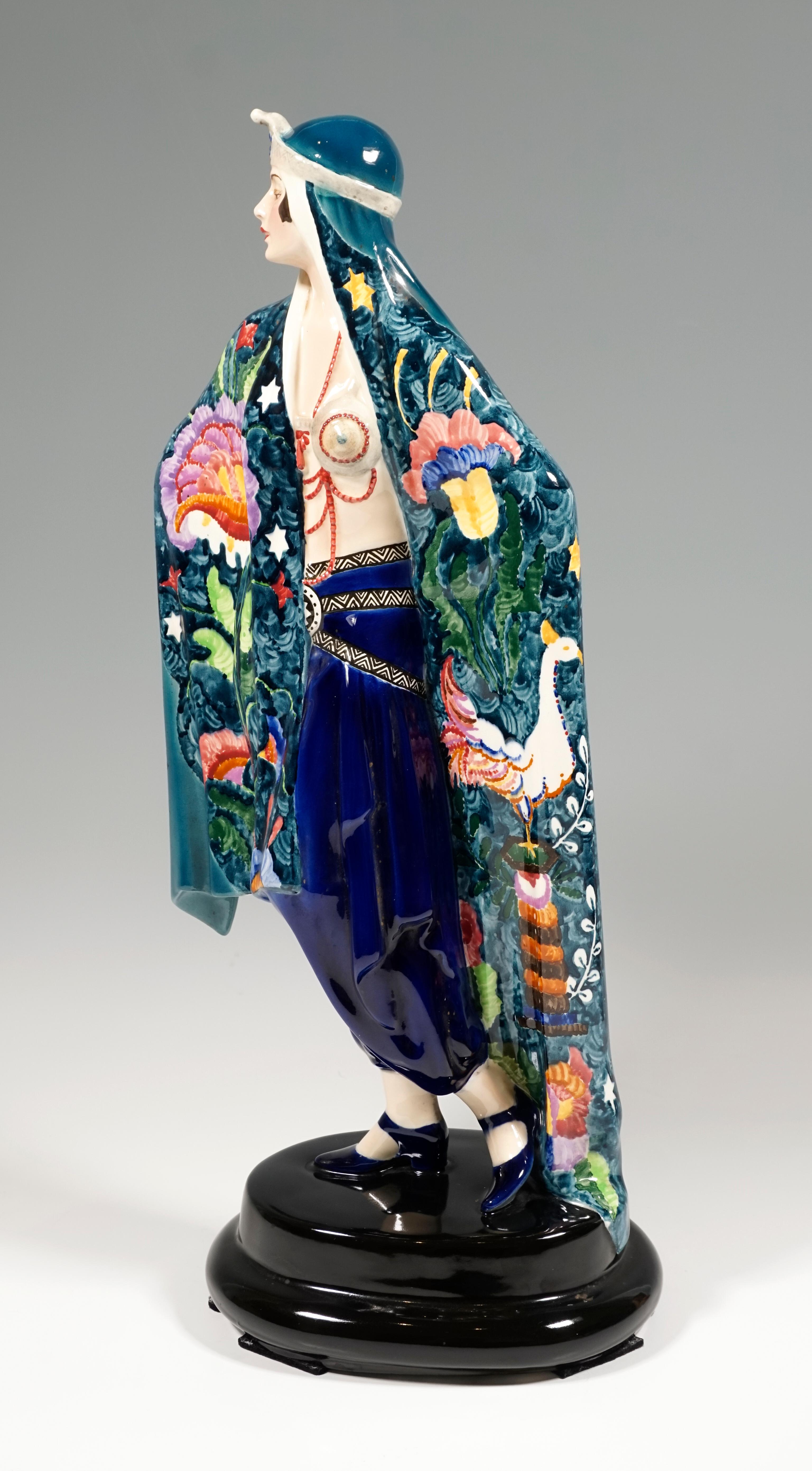 Very exceptional decorated Goldscheider Art Deco ceramic figure of the 1920's:
Depiction of a standing, proudly looking to the side lady in oriental garb. She is wrapped in a large blue-green cloth that reaches down to the floor, the front of which
