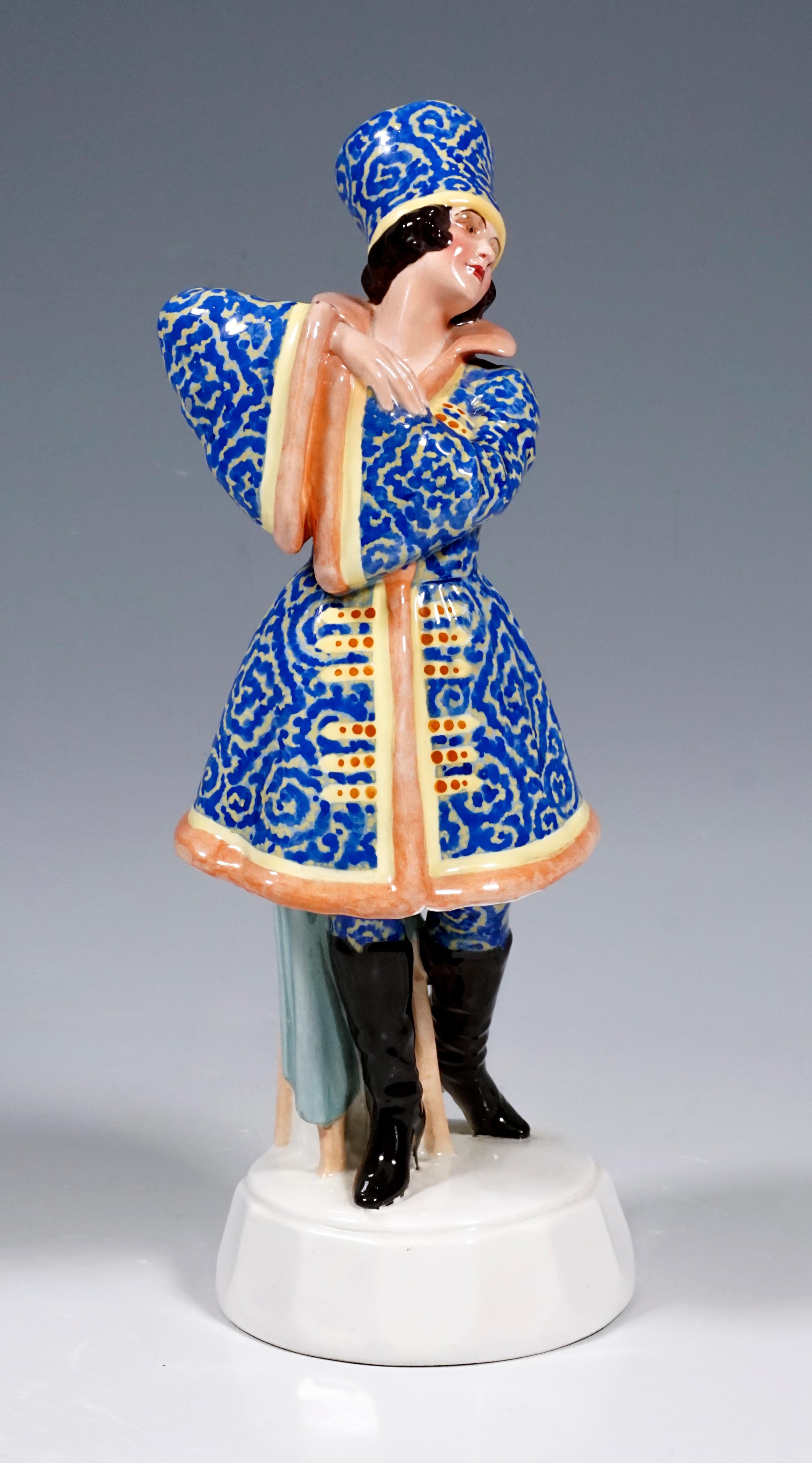 Sehr seltene Goldscheider Wien Figur aus den 1920er Jahren
Gezeigt wird eine stehende Tänzerin, die mit verschränkten und vor ihr erhobenen Armen zur Seite schaut. Die junge Dame trägt ein russisches Kostüm, das mit aufwendigen blauen Stickereien