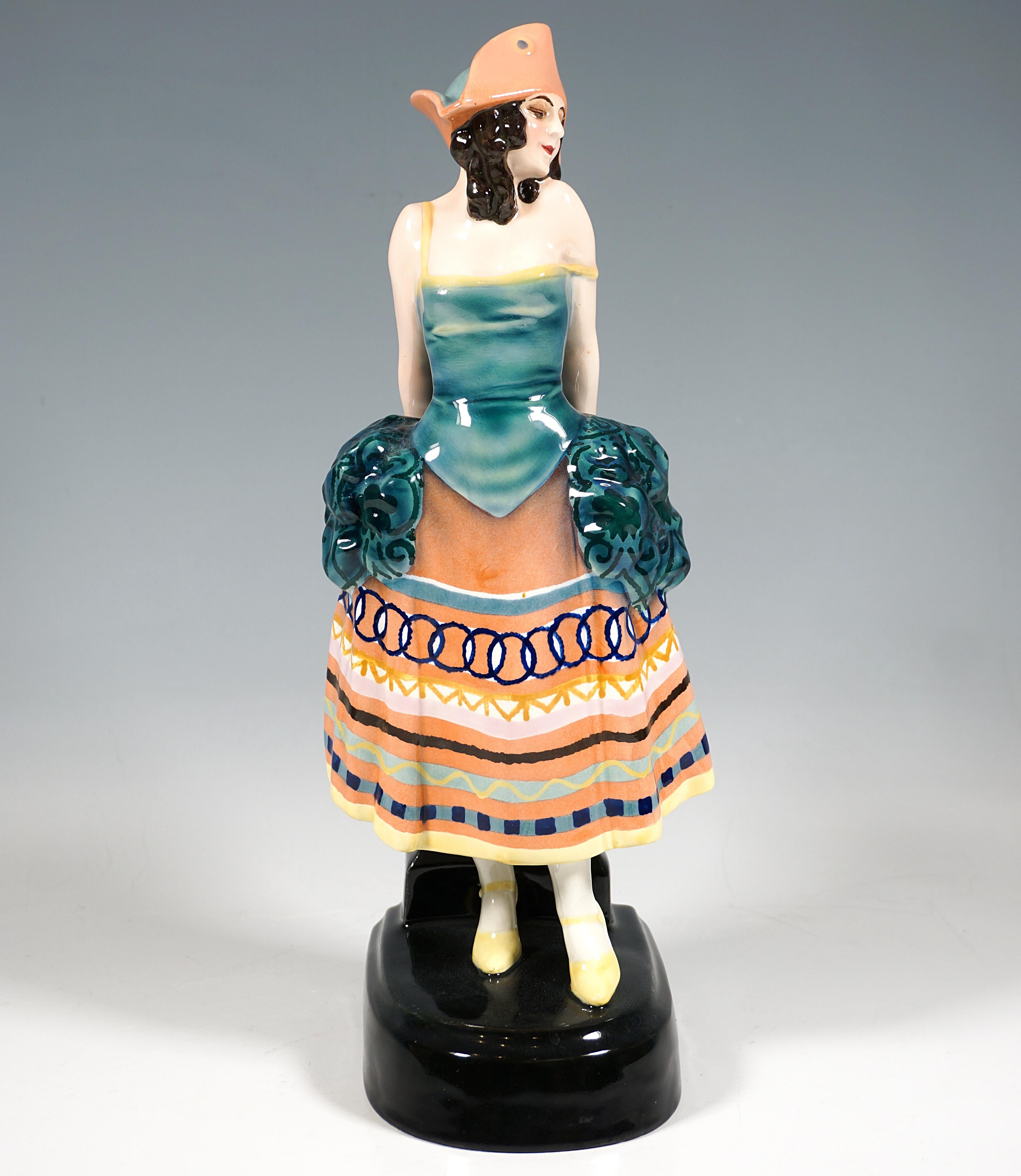 Rare figurine Goldscheider Vienna Art Déco des années 1920 :
Jeune femme debout en costume de carnaval inspiré du style rococo avec de délicates bretelles et un décolleté, une longue jupe avec des rubans à motifs croisés et des bouffées de tissu