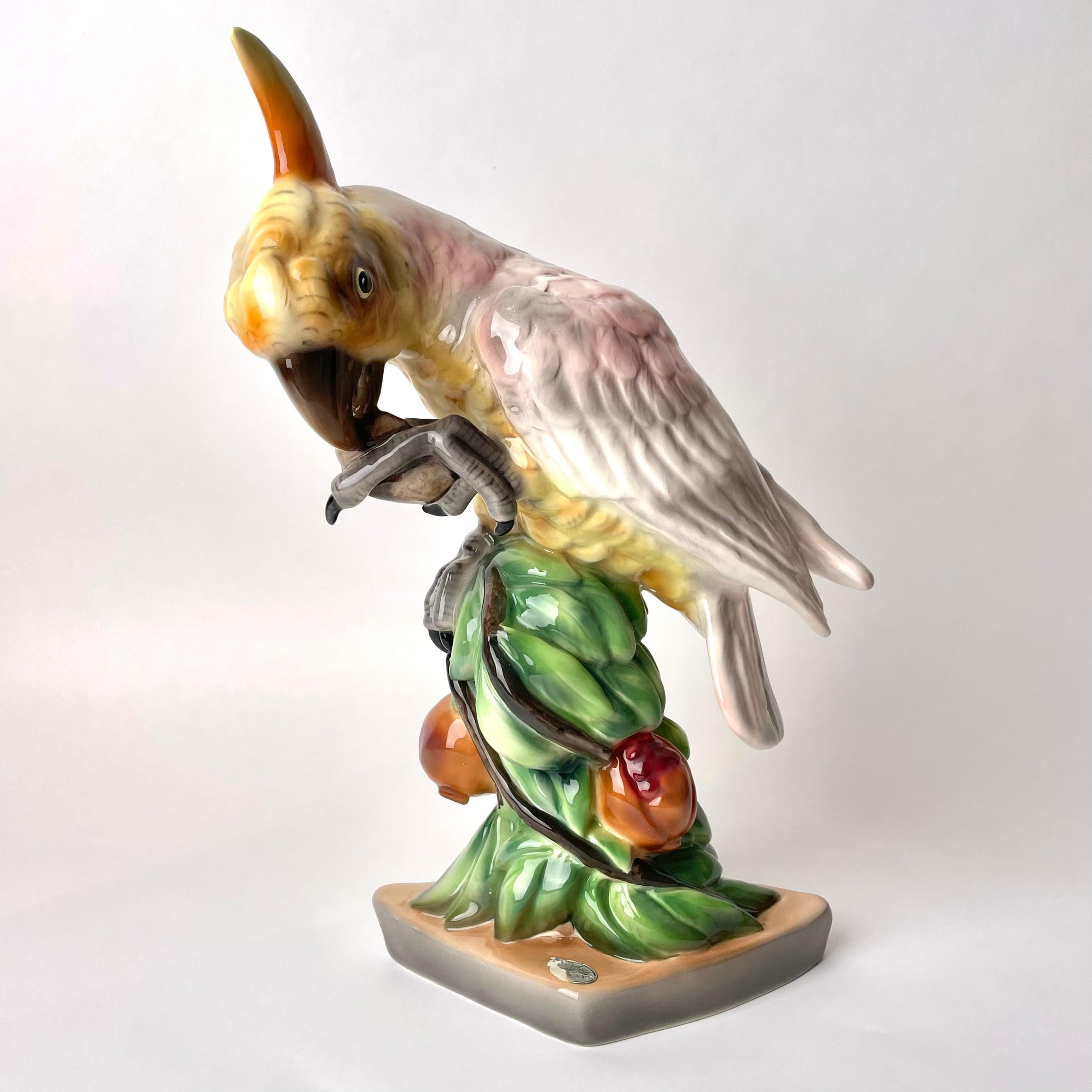 Figurine en céramique viennoise en forme de perroquet assis sur une Branch avec une pomme, probablement années 1920

Cette charmante figurine en porcelaine a été fabriquée par la célèbre entreprise viennoise de céramique Goldscheider. L'entreprise a