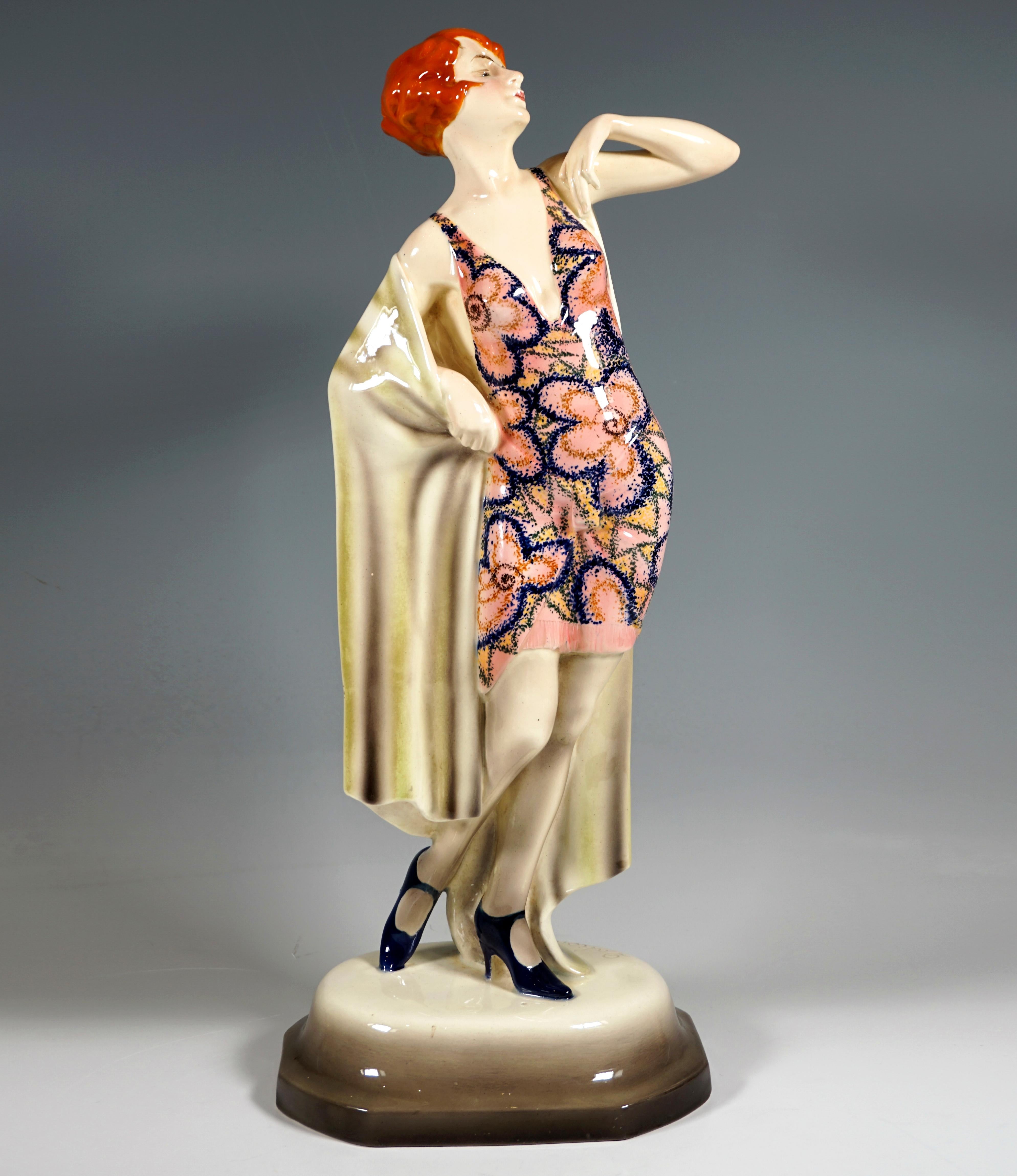 Seltene große Goldscheider Art-Déco-Keramikfigur aus den 1920er Jahren:
Junge Dame mit Kurzhaarfrisur in einem kurzen, tief ausgeschnittenen Trägerkleid mit großem Blumenschmuck, lasziv und selbstbewusst posierend: erhobener Kopf mit geschlossenen