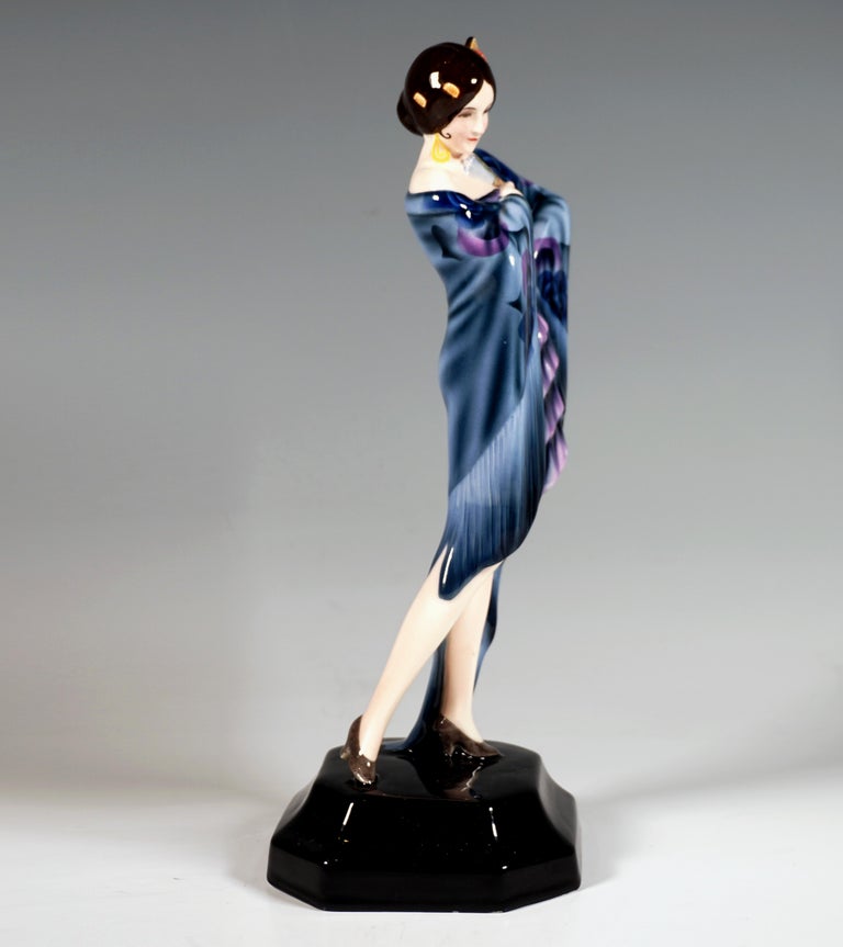 Rare Goldscheider Art Deco Ceramic Figure of the 1930's: 
Depiction of Dolores del Rio, a Mexican film actress, as a Spanish dancer: A standing pretty woman, her hair tied in a bun at the nape of her neck, with a side, fan-like hair comb decorated