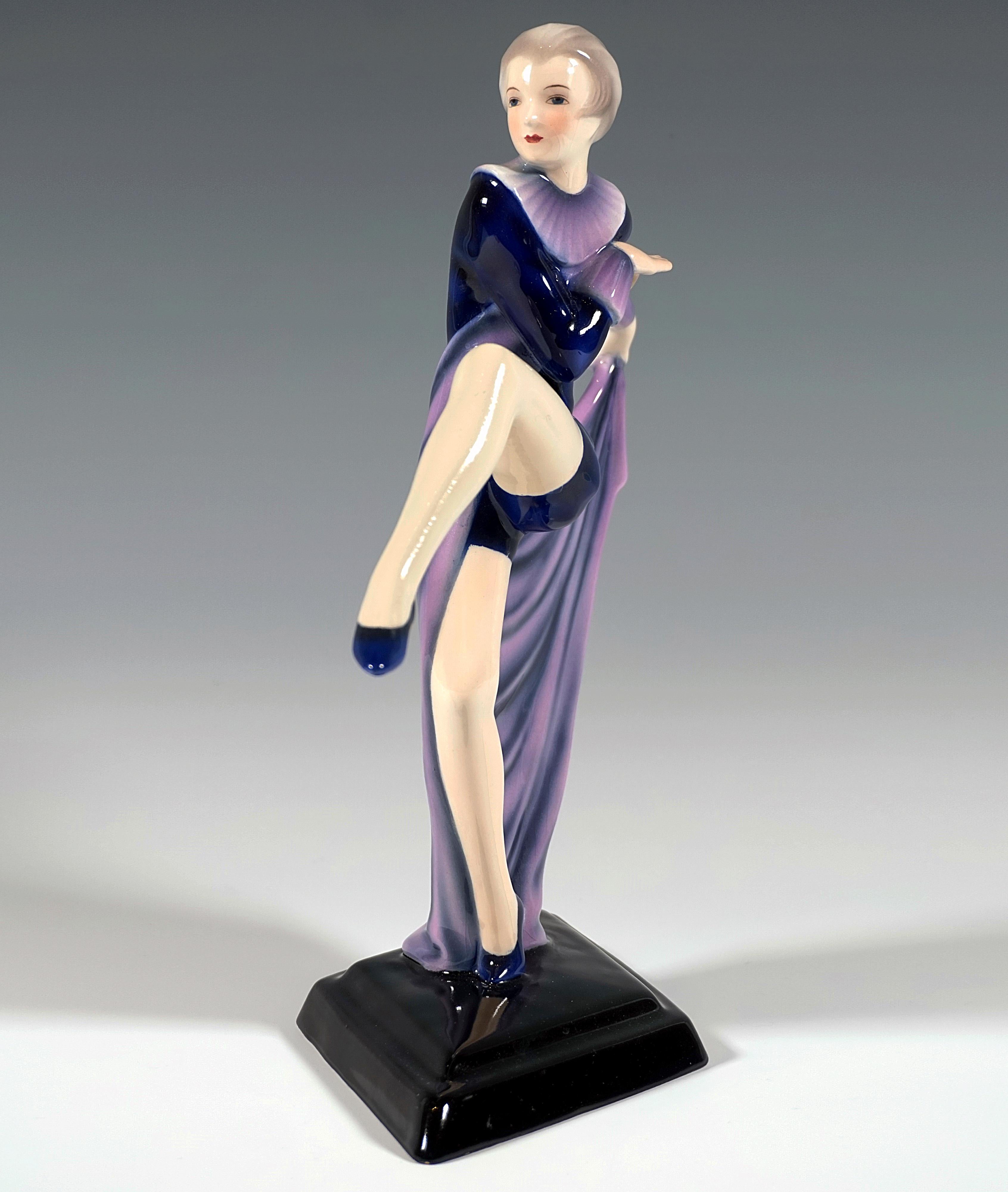 Exquisite porcelain figurine of the 1930:
Aparte dancer in a tight-fitting dark blue costume with short trouser legs and ruff, gymnastic shoes on her feet, balancing on the ball of her right toe, throwing her left leg up to the front, turning her