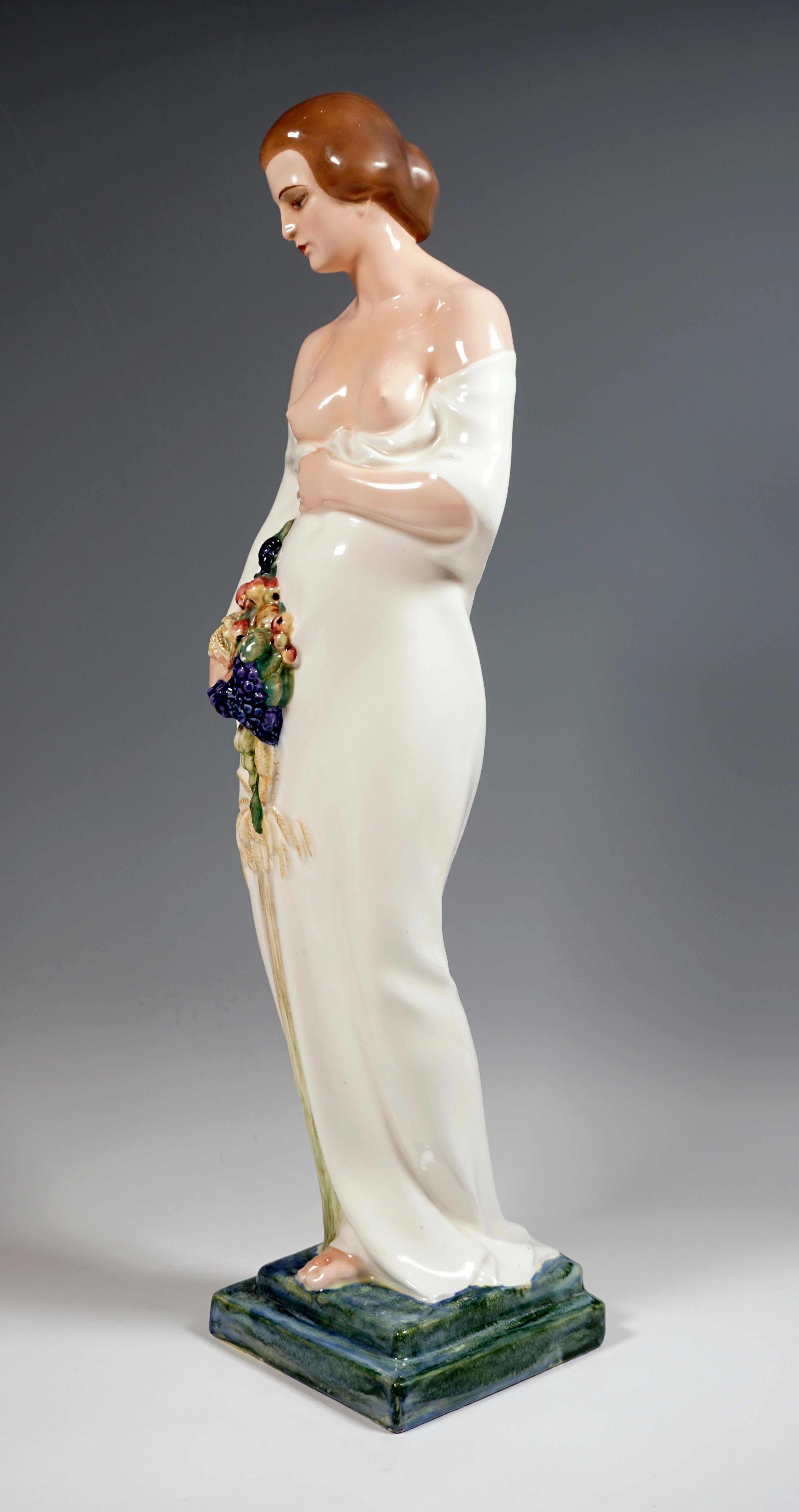 Very large and rare Goldscheider ceramic figurine of the 1920s:
Standing young lady with her hair pinned up, holding a large, softly falling white cloth that surrounds the shapely body with her left hand below her bare breast in front of her body,