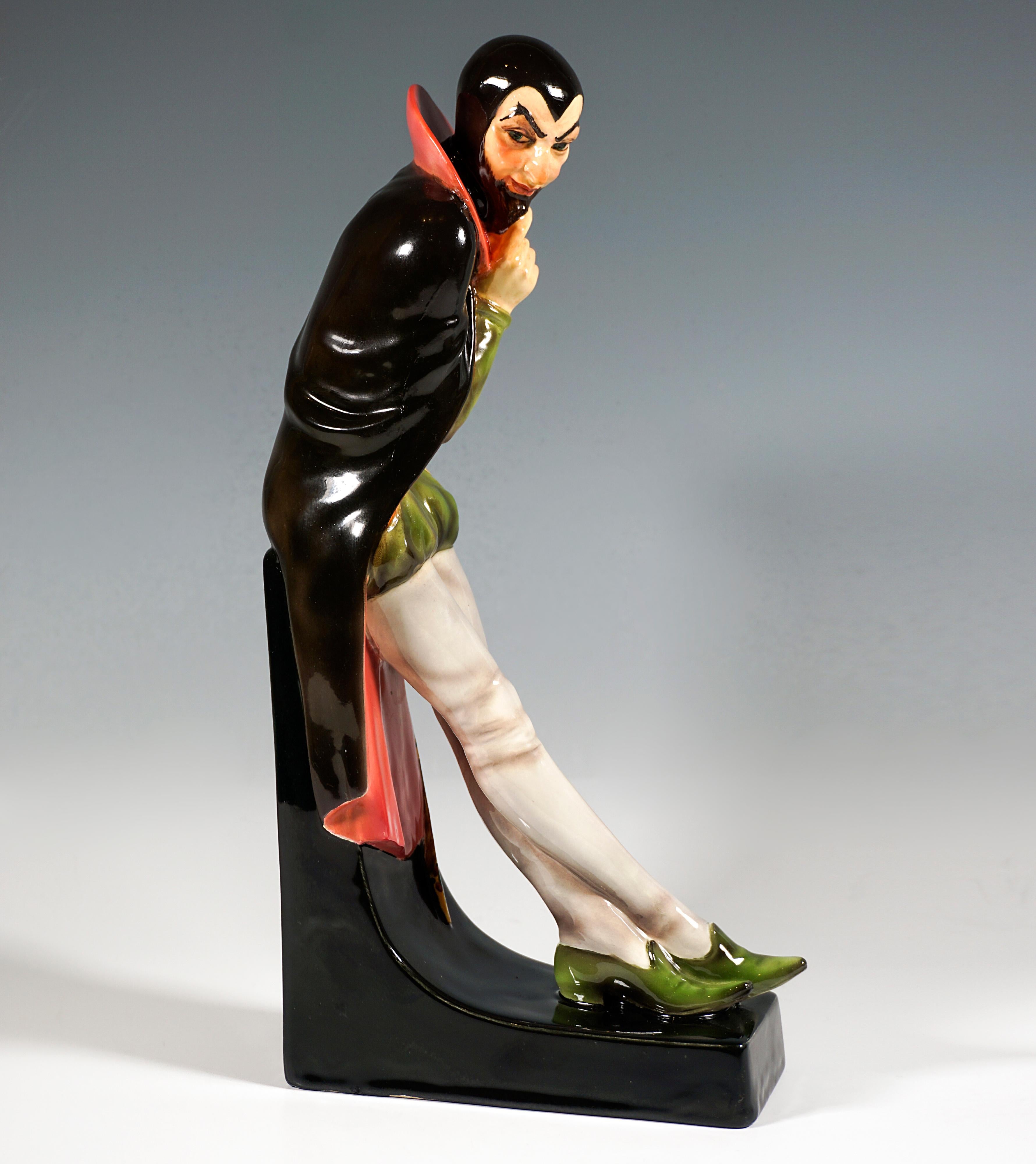 Ausgezeichnete Goldscheider Art Deco Keramikfigur aus den 1920er Jahren:
Männliche Figur, mit gekreuzten und nach vorne gestreckten Beinen auf ein hohes Podest gelehnt, leicht nach vorne gebeugt, mit der rechten Hand den Ziegenbart haltend,
