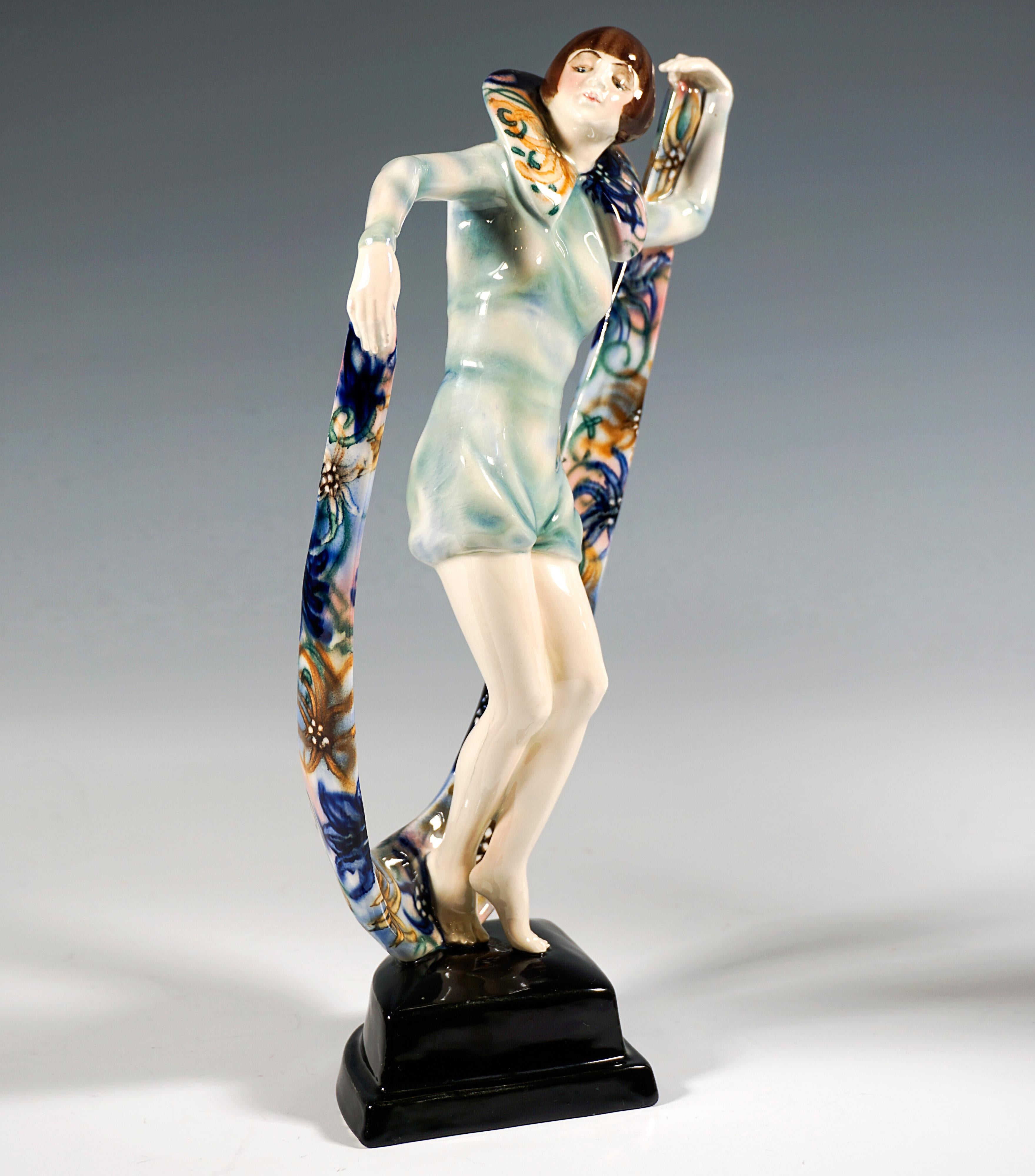 Giovane ballerino di revue con acconciatura da paggio, vestito con un costume intero verde chiaro trasparente con pantaloni corti e top aderente a maniche lunghe con ampio colletto in piedi all'indietro, in equilibrio sulla punta dei piedi mentre