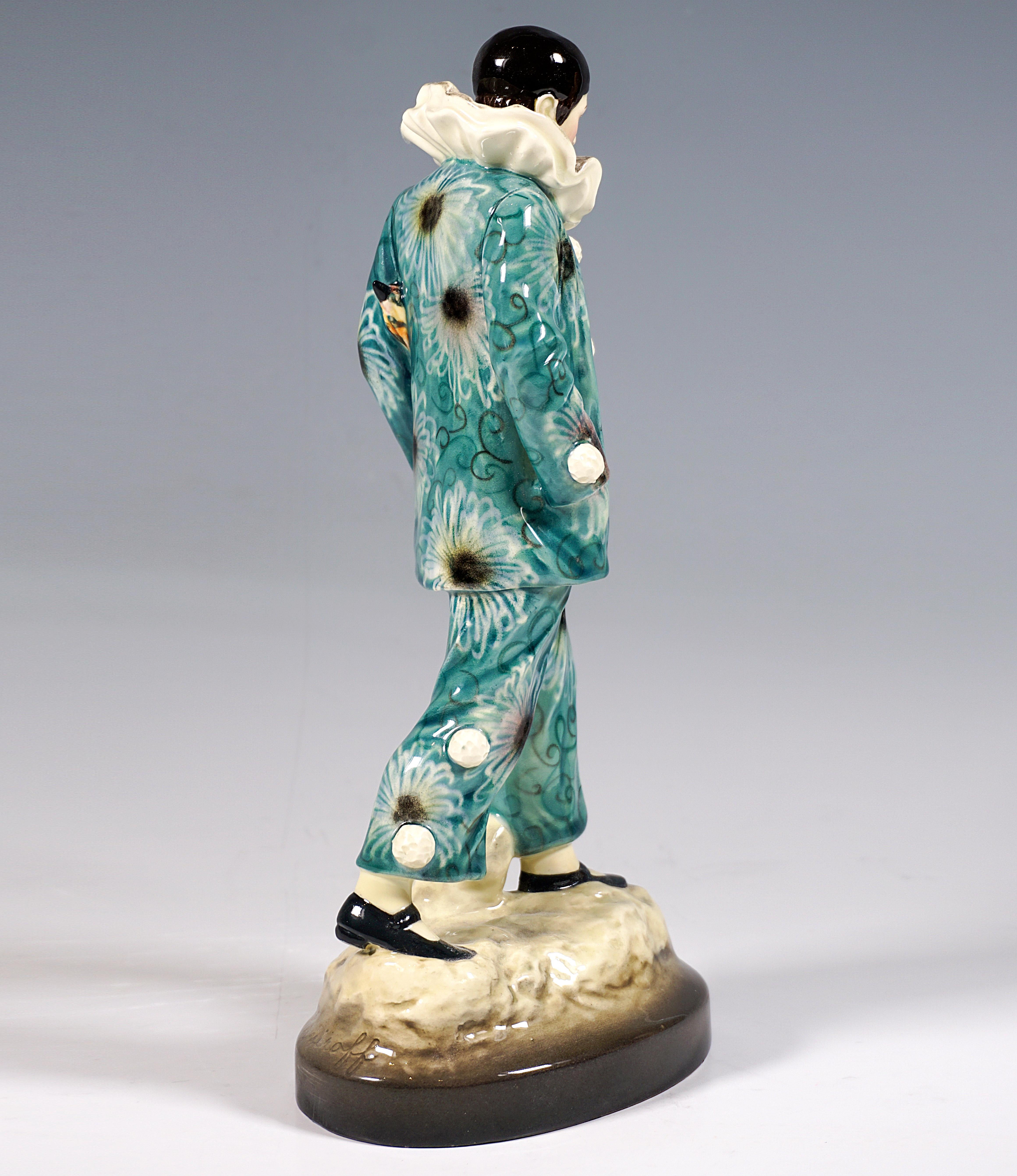 Exceptional Goldscheider Figurine of the 1920s after an Art Nouveau Design:
Representation of a thoughtfully walking harlequin in an elaborate costume decorated with a large floral pattern in turquoise and shades of gray, white tassel buttons,