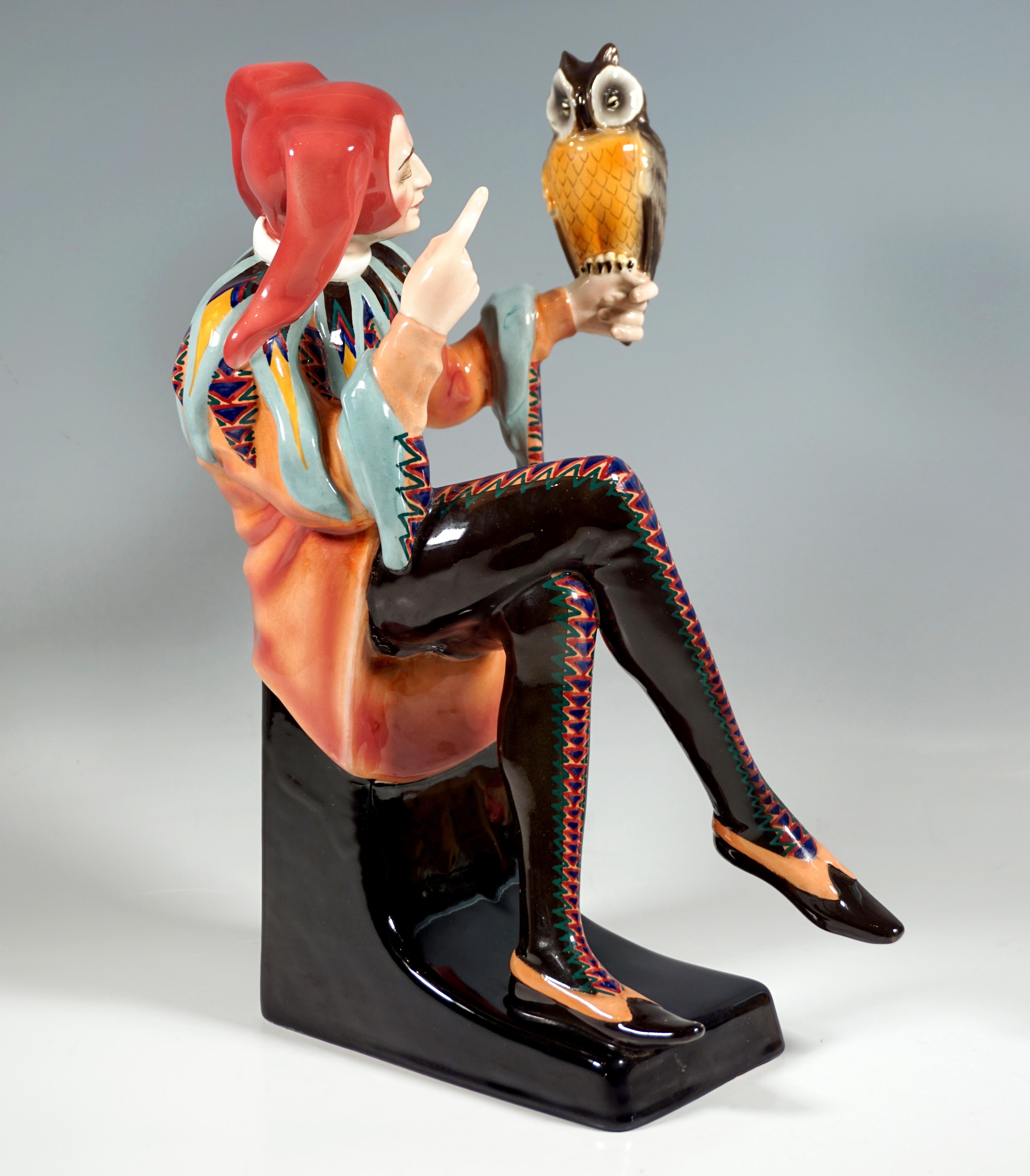 Exceptional Art Déco Goldscheider Figurine by Josef Lorenzl:
Man disguised as a jester with jester's cap, wide shirt and tight trousers with a zigzag pattern seated on a black pedestal, on his left outstretched hand an owl, symbol of prudence and