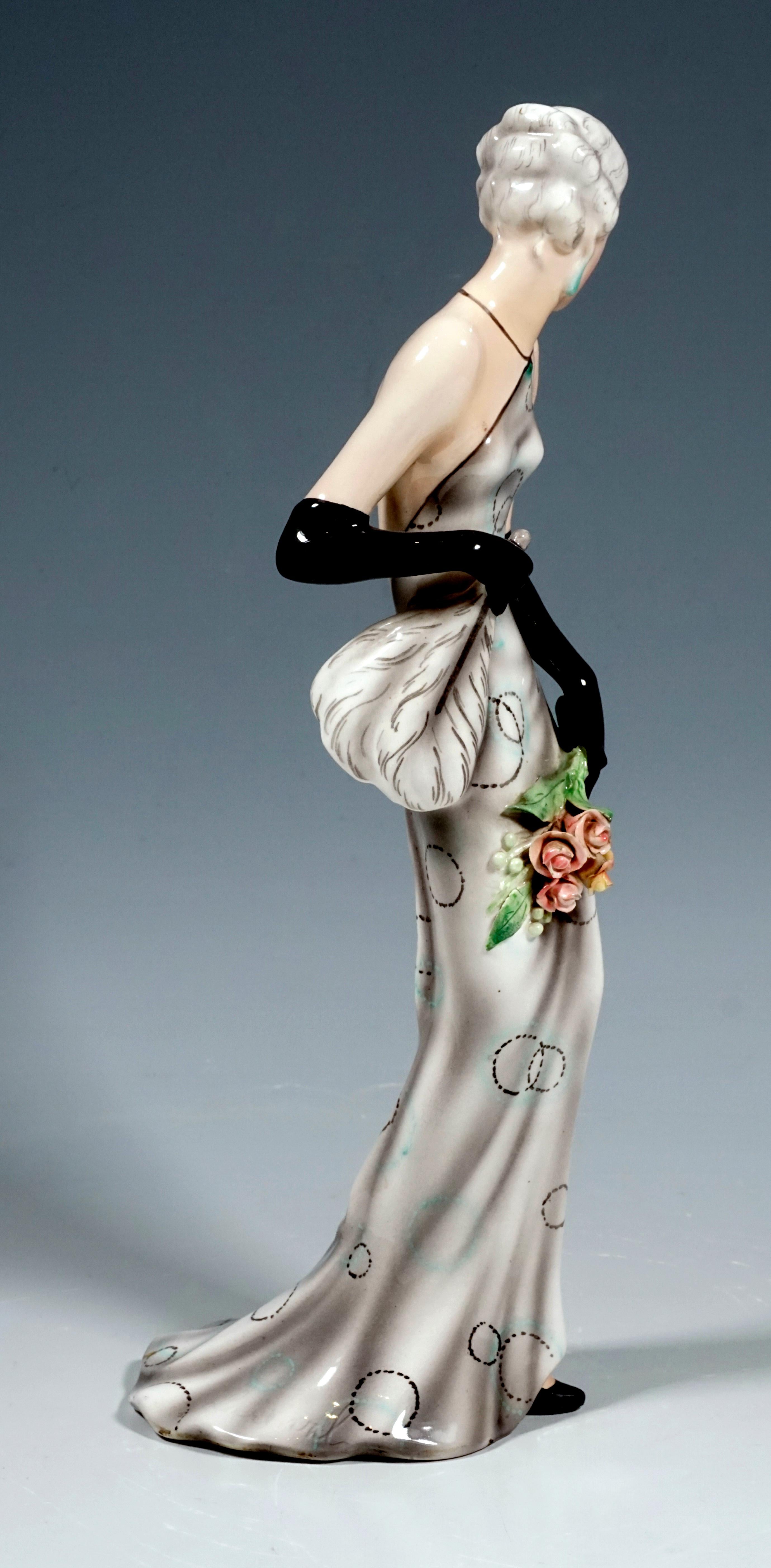 Very rare Goldscheider Vienna figurine of the 1920s
Depiction of an elegant lady in a long, tight-fitting, backless dress in light gray-beige with delicate, dotted, black and turquoise circular decoration and a wide skirt. She also wears long black