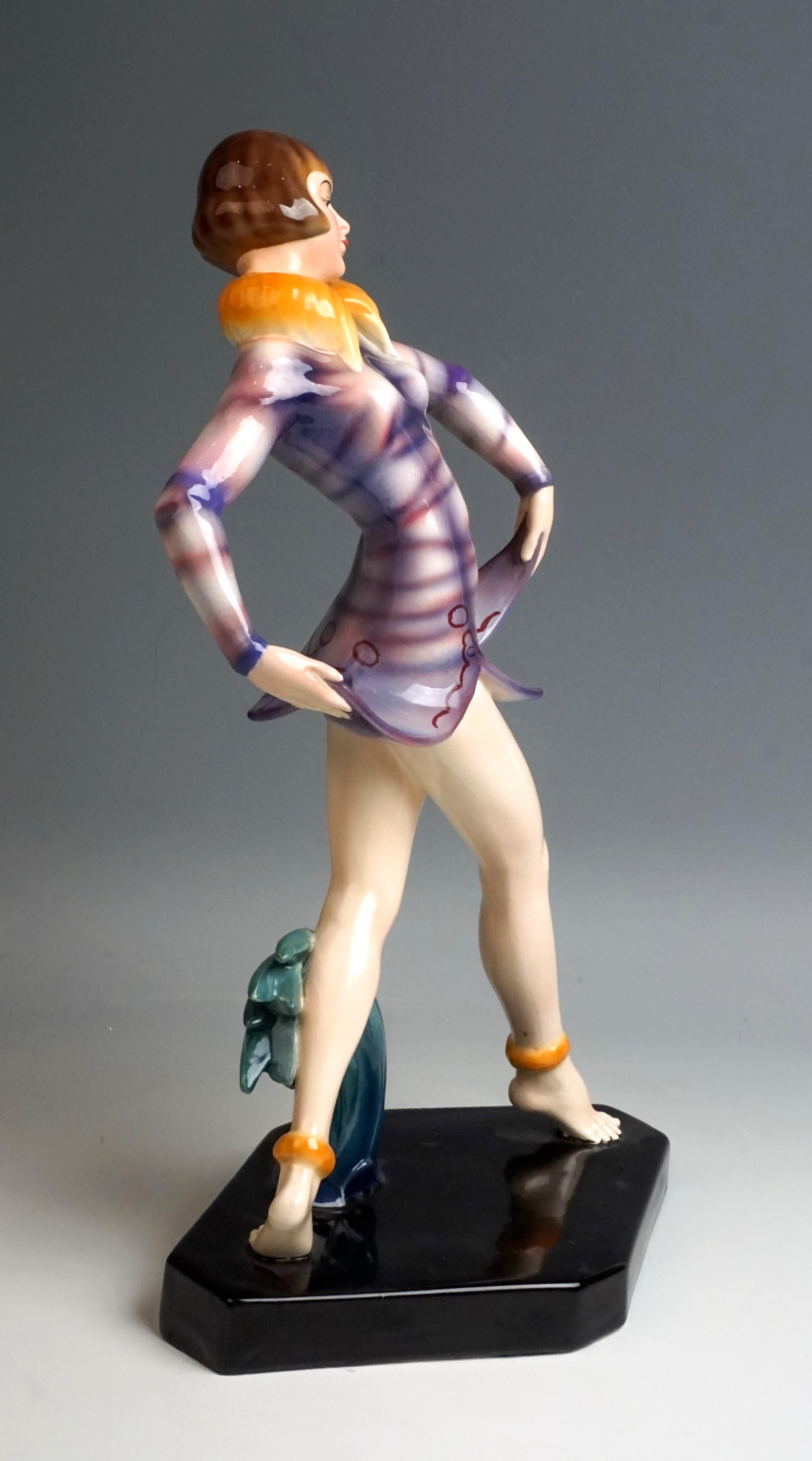 Remarkable Art Déco Goldscheider ceramics figurine of the 1930s

Standing young revue dancer with pageboy hairstyle, taking a step forward. At the same time she lifts the bellflower-shaped hem of her short purple dress with a fur collar with both