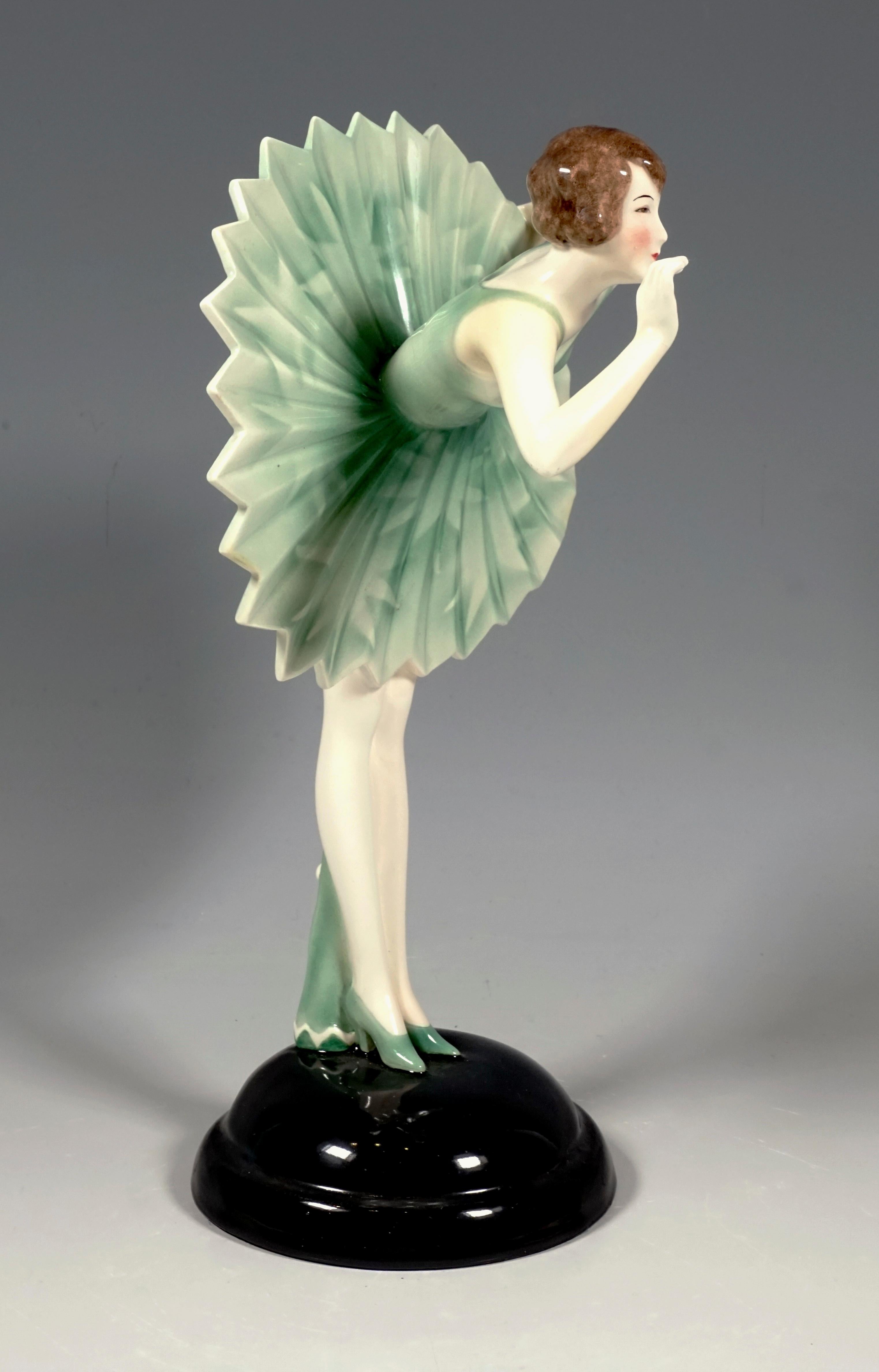 Bemerkenswerte Art Deco Goldscheider Keramikfigur aus den 1930er Jahren:
Junge Tänzerin mit kurzen Haaren, die sich vor ihrem Publikum verbeugt, so dass der Faltenrock mit Zickzack-Saum sternförmig absteht, hinter ihr auf dem Boden liegt ein