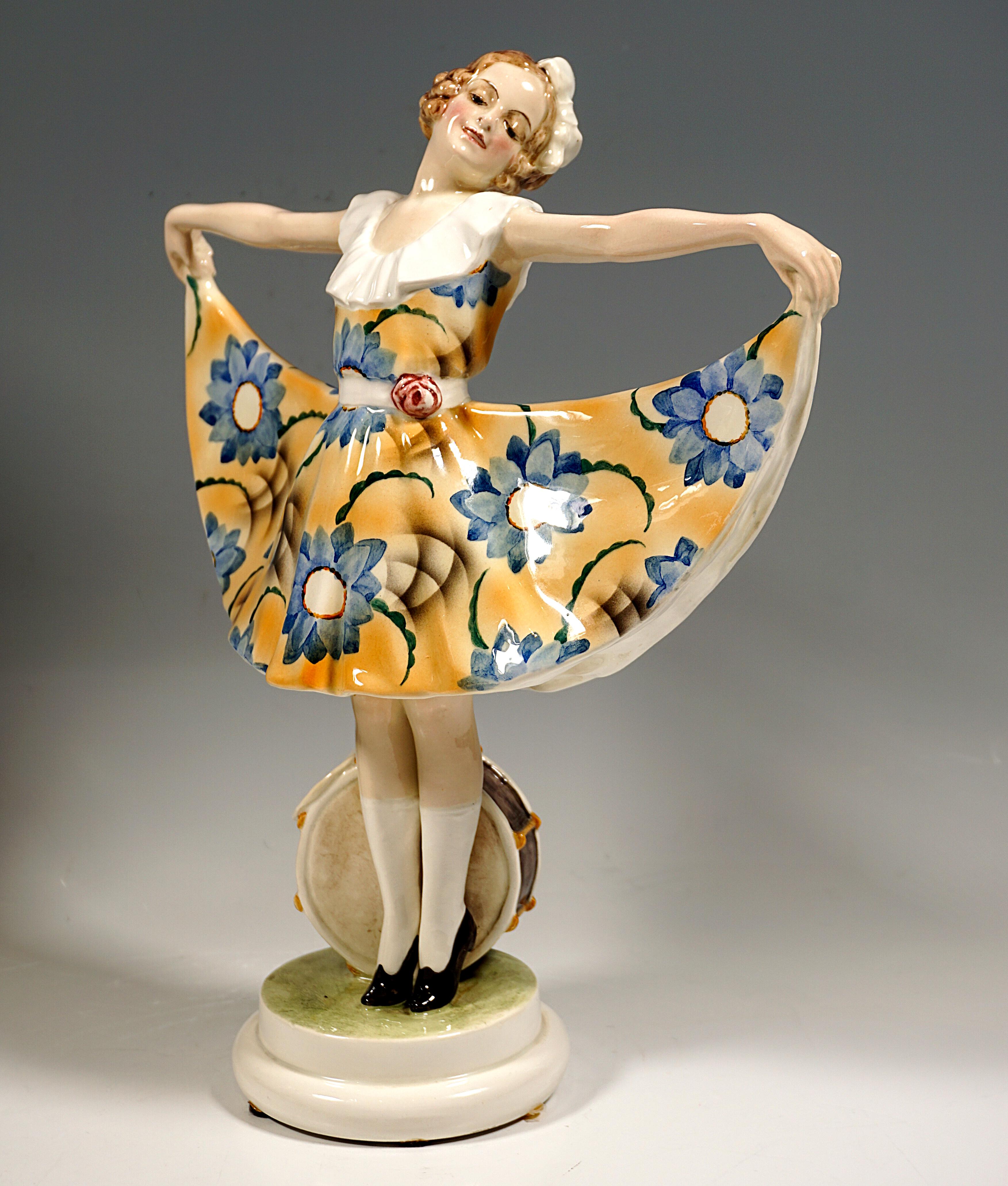 Rare Goldscheider Ceramics Figure of the 1920s.
Representation of a young dancer in a knee-length dress with a white flounce neckline, elaborately decorated with blue flowers against a yellow background, with her arms outstretched to the side,