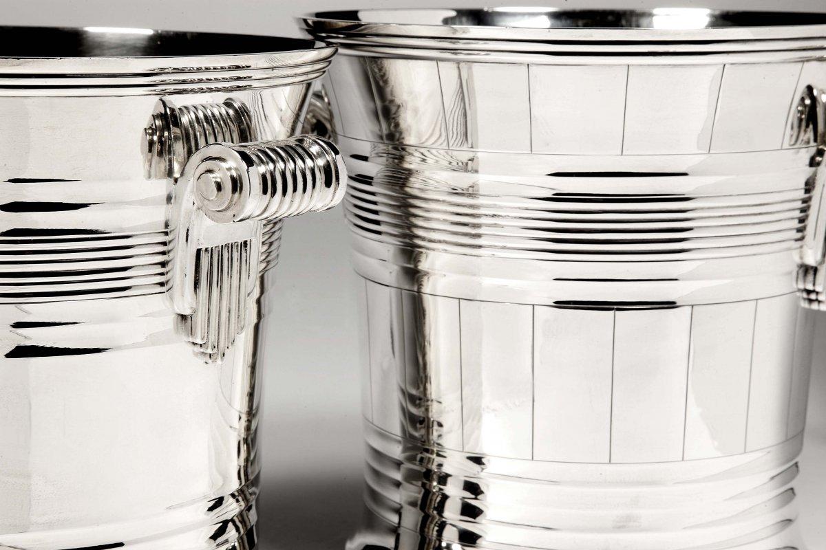 Pair of solid silver coolers of cylindrical shape slightly flared towards the neck, decorated with nets for one and a variant

for the other with vertical grooves. On each side are two roll-up handles in the purest art deco style.

Goldsmith: 