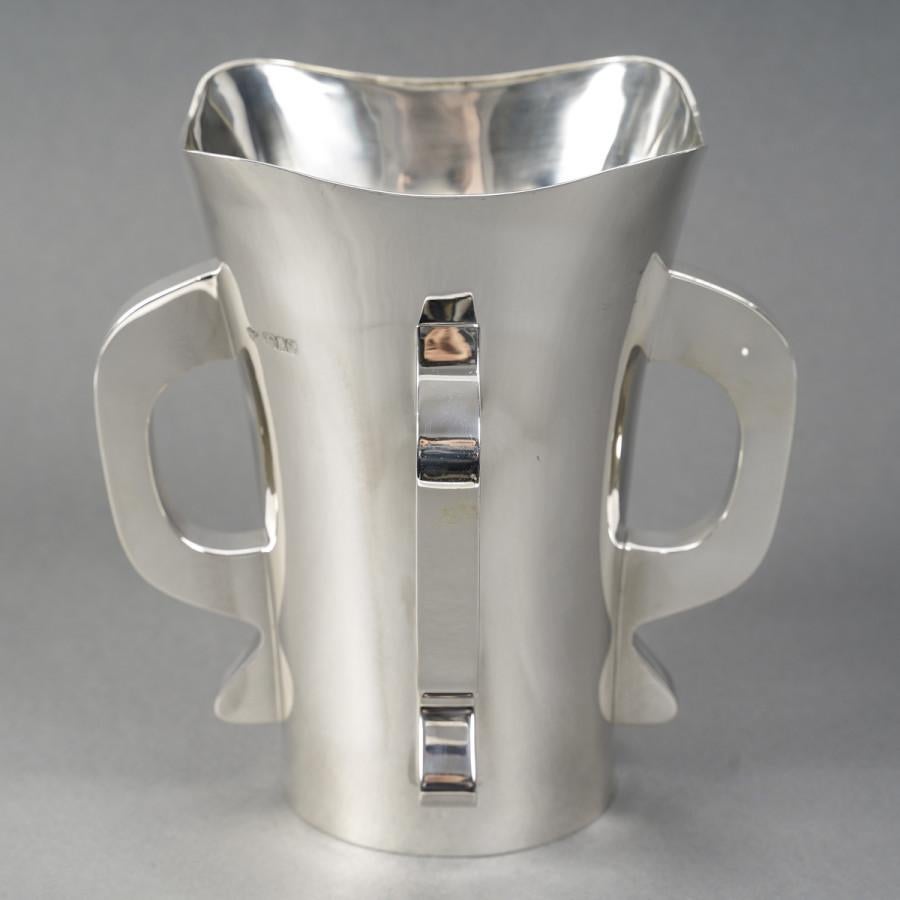 Vaso modernista in argento massiccio a base rotonda leggermente svasata verso il collo, corpo liscio affiancato da quattro maniglie nello stile di transizione tra art nouveau e art deco. Un pezzo molto originale realizzato all'inizio del XX secolo.