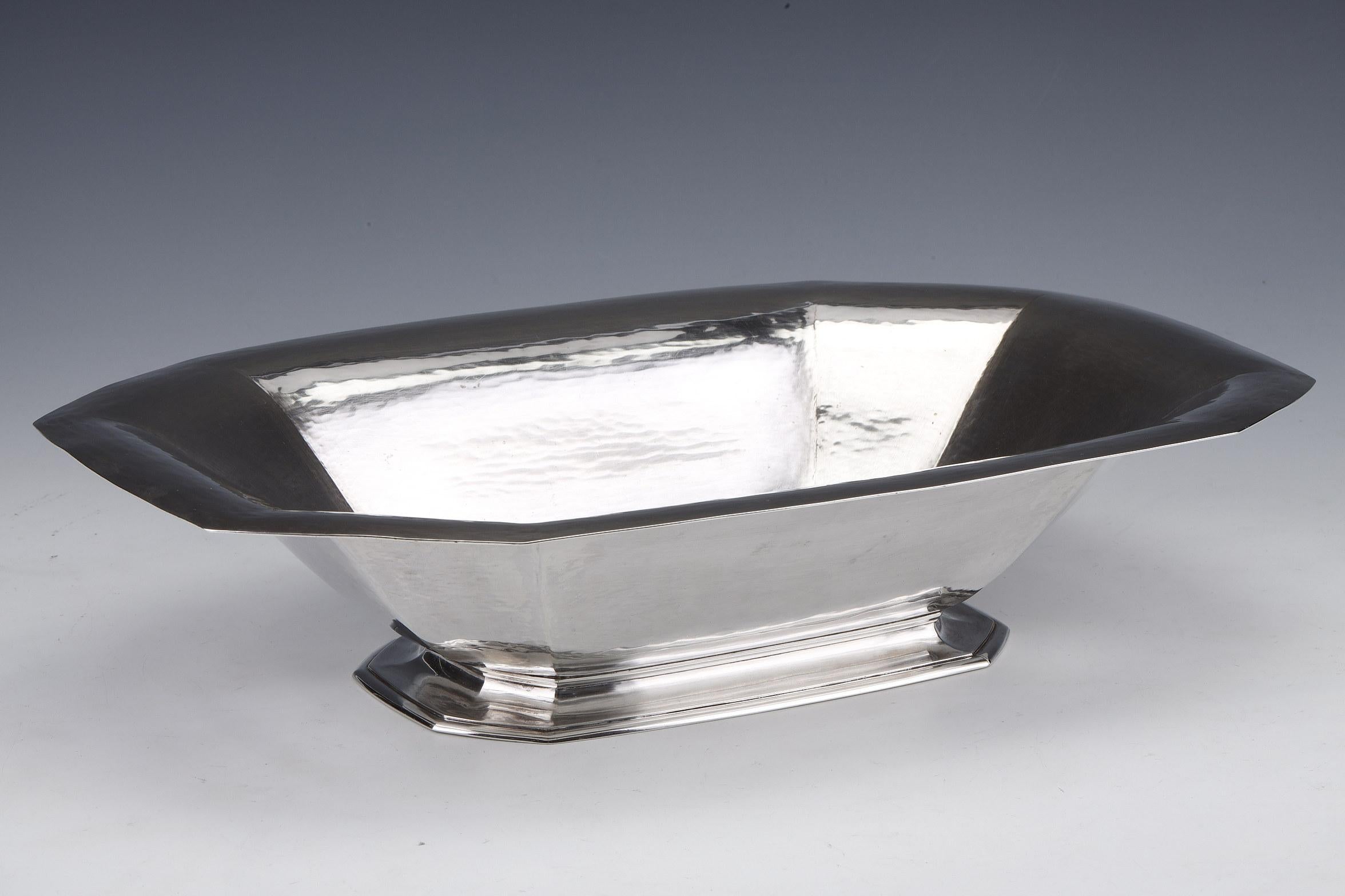 Large solid silver centerpiece plain model mounted on a rectangular and octagonal pedestal on which is placed a hollow cup with canted sides.
Dimensions: length 40 cm width 27 cm height 8.5 cm
Material: silver 1st grade 950/°°°
Weight: 1285