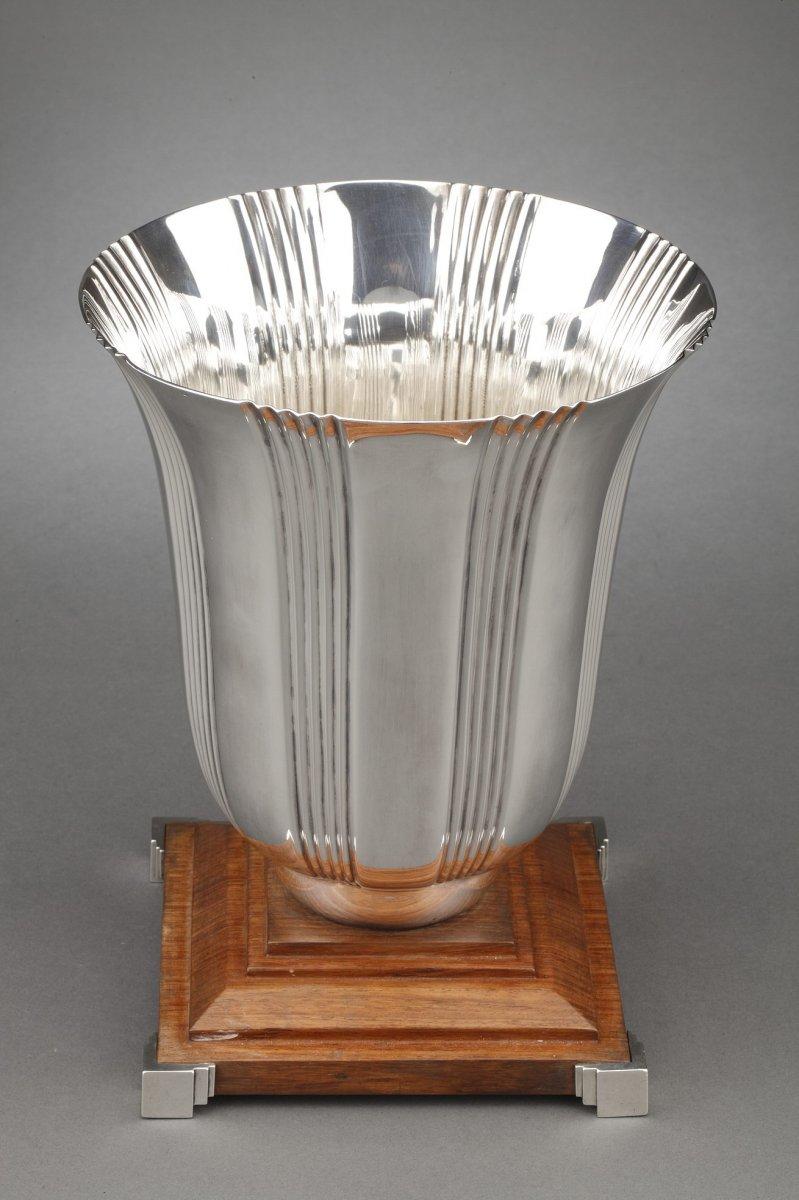 Large baluster-shaped solid silver vase decorated with vertical grooves, fixed on a stepped wooden base set with silver at the four corners.
Dimensions: height: 27.5 cm - diameter 21.5 cm - base 17.5 cm
Material: silver 1st grade
Weight: 2.475 grams