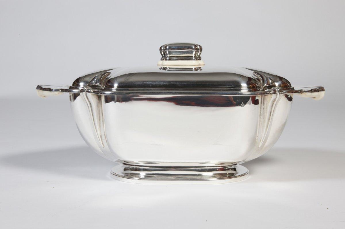 Table centerpiece in the shape of a rectangular tureen in solid silver placed on a bat, the body is plain and covered.

The grip and the handles are in silver and ivory.

Rare piece executed by RUYS in part, hammered.

Dimensions: Height: 18 cm,