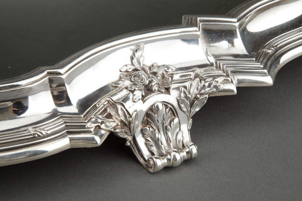 Le centre de table festonné, avec un fond en miroir sur un parquet en chêne, est entouré d'une lingotière en argent massif décorée de filets et d'agrafes solides. Le centre repose sur six pieds à enroulement décorés de feuillages, flanqués de chaque