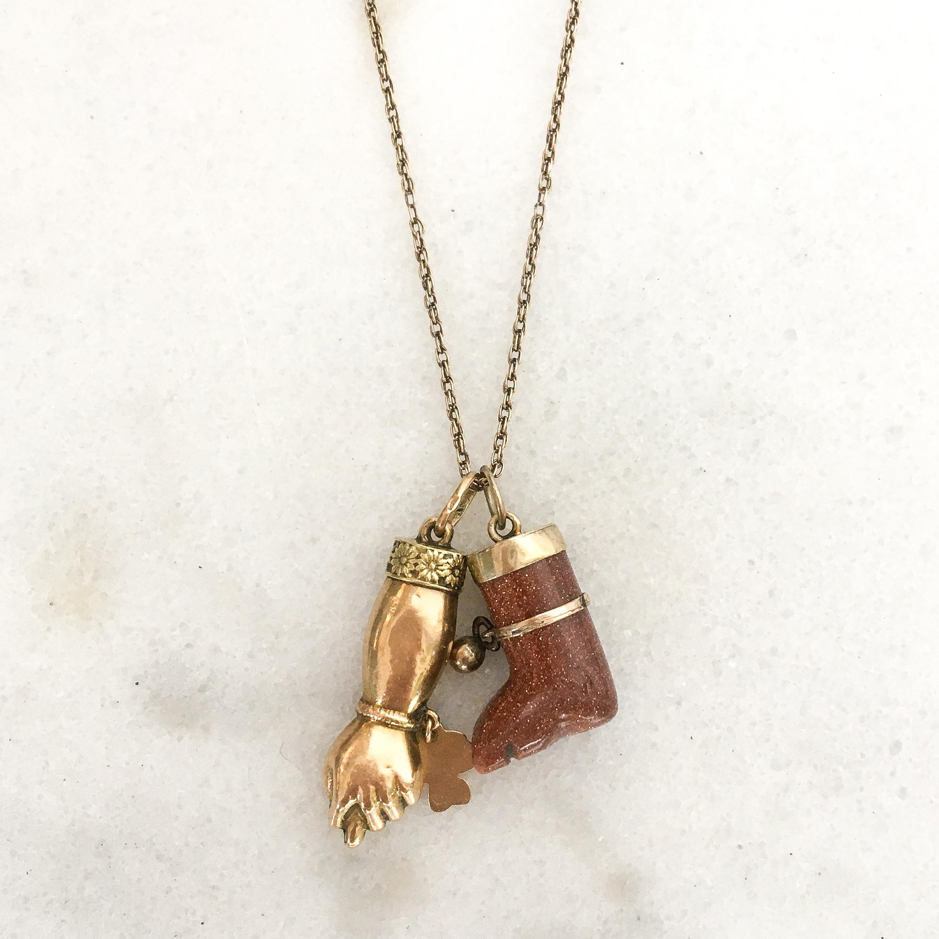 A vintage figa leg ex voto charm pendant, crafted in goldstone and 14 karat gold. The glittering religious offering leg is smooth polished with carved toes. Around the leg a gold band with a little ball is placed. The charm is great worn alone or