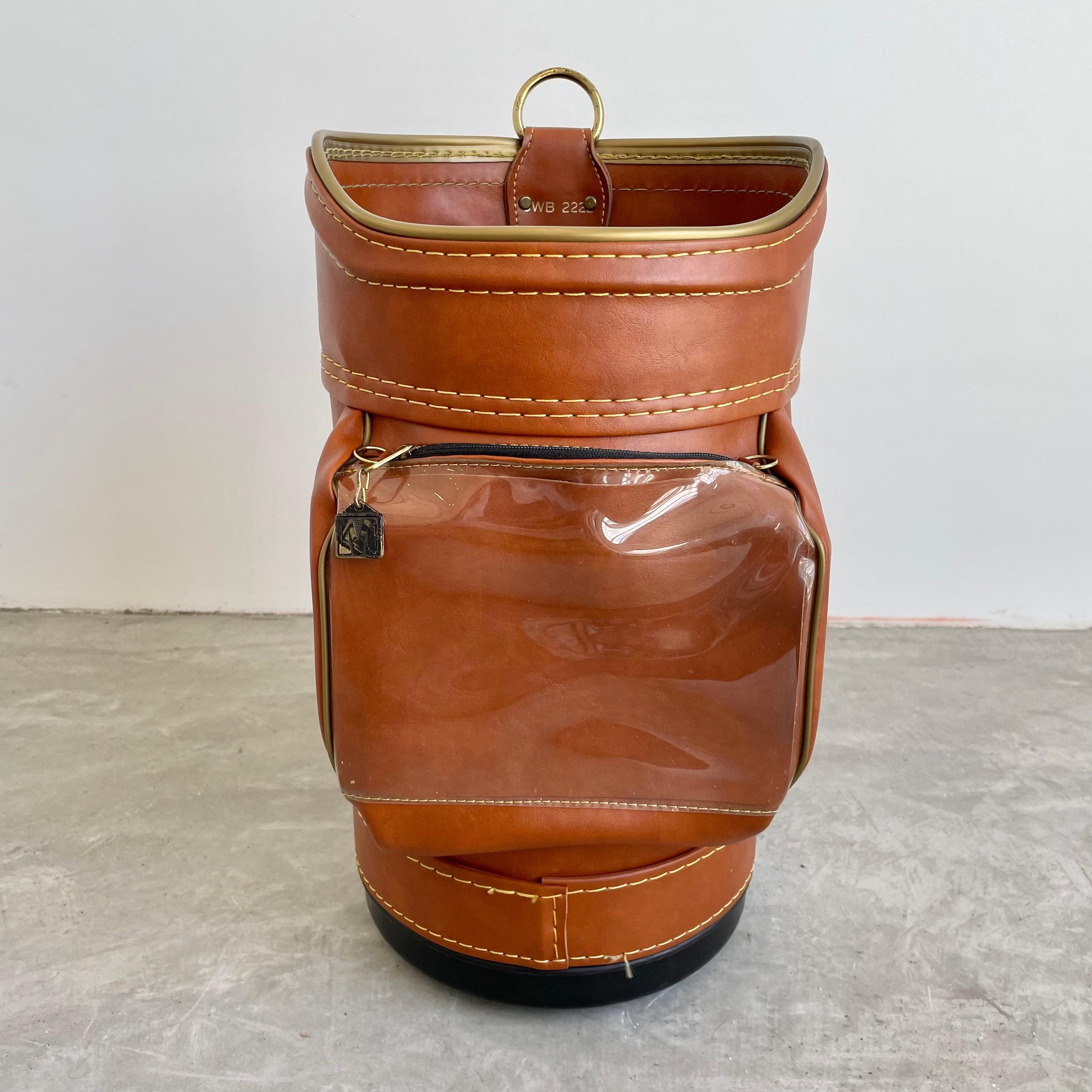 Golf bag waste bin by Miller golf. Made in a synthetic leather and a plastic inner bin with brass hardware throughout. Two functional zipper pockets on front and back. Good vintage condition. Great gift for a golfer.