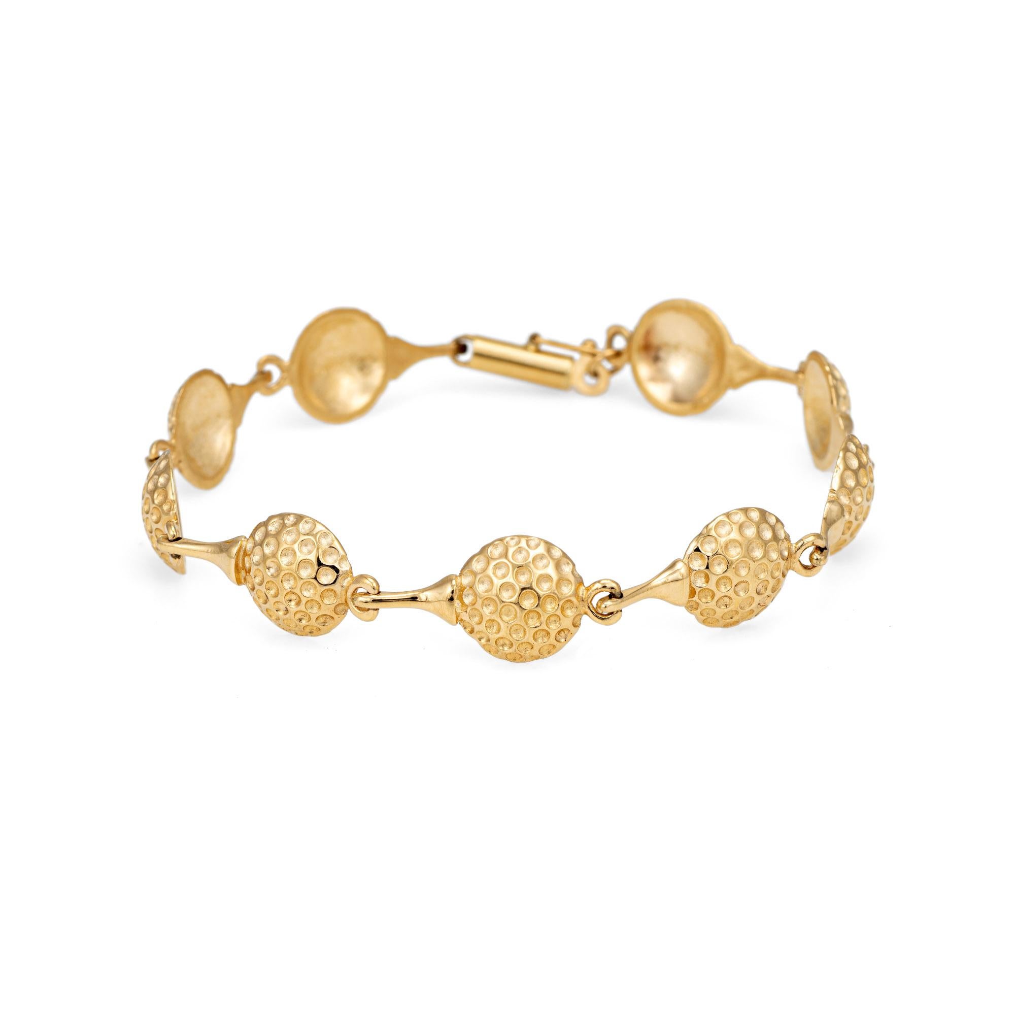 Distinct and stylish golf ball bracelet crafted in 14k yellow gold. 

Linked golf balls set upon a tee forms the distinct bracelet. The bracelet is great worn alone or layered. 

The bracelet is in very good condition and was lightly cleaned and