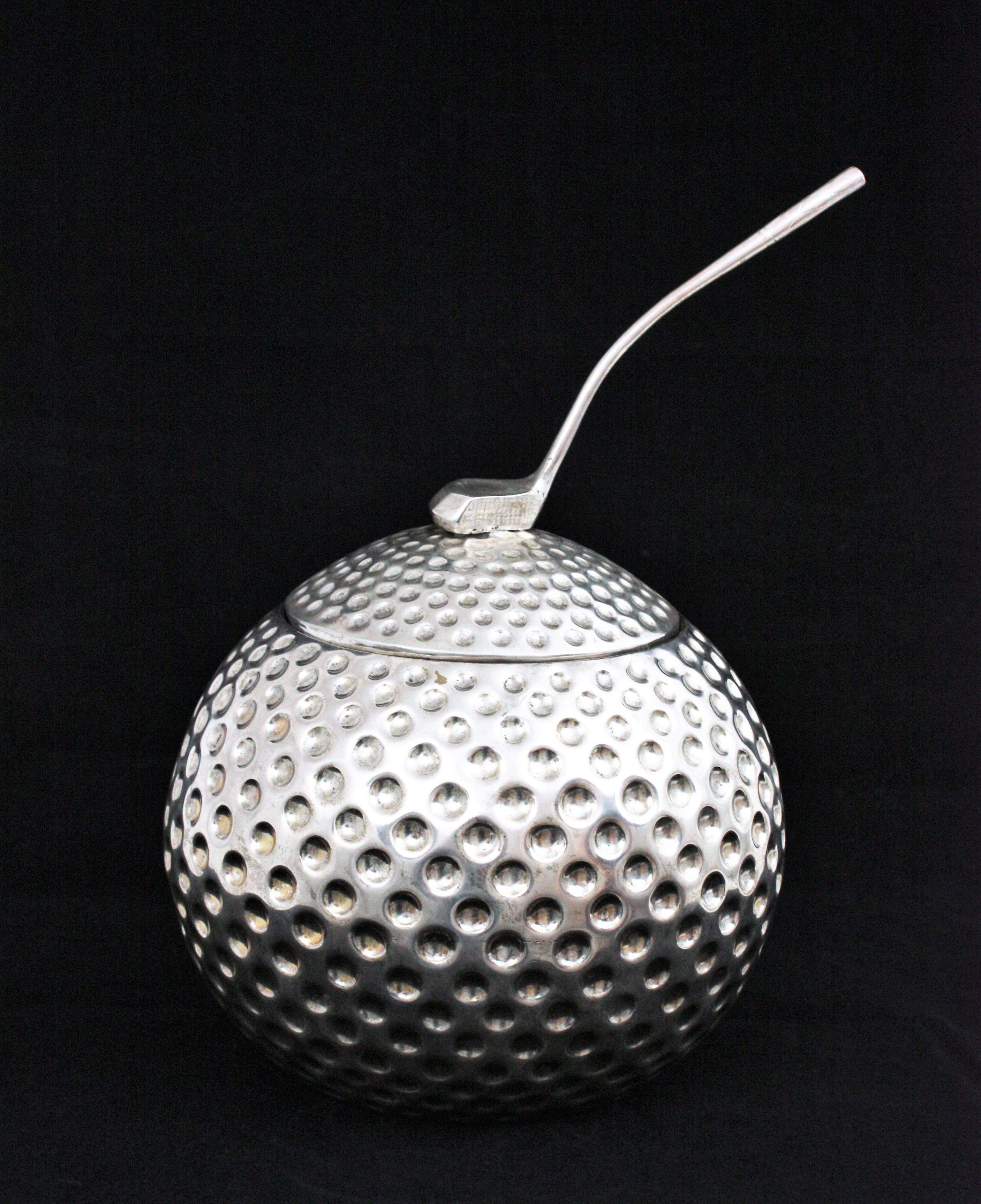 An exquisite Hollywood Regency silvered metal golf ball shaped ice bucket or wine chiller. Designed and manufactured by Valenti. Spain, 1960s.
This unusual golf ball was designed to be used as an ice bucket or wine chiller. It has a golf club on