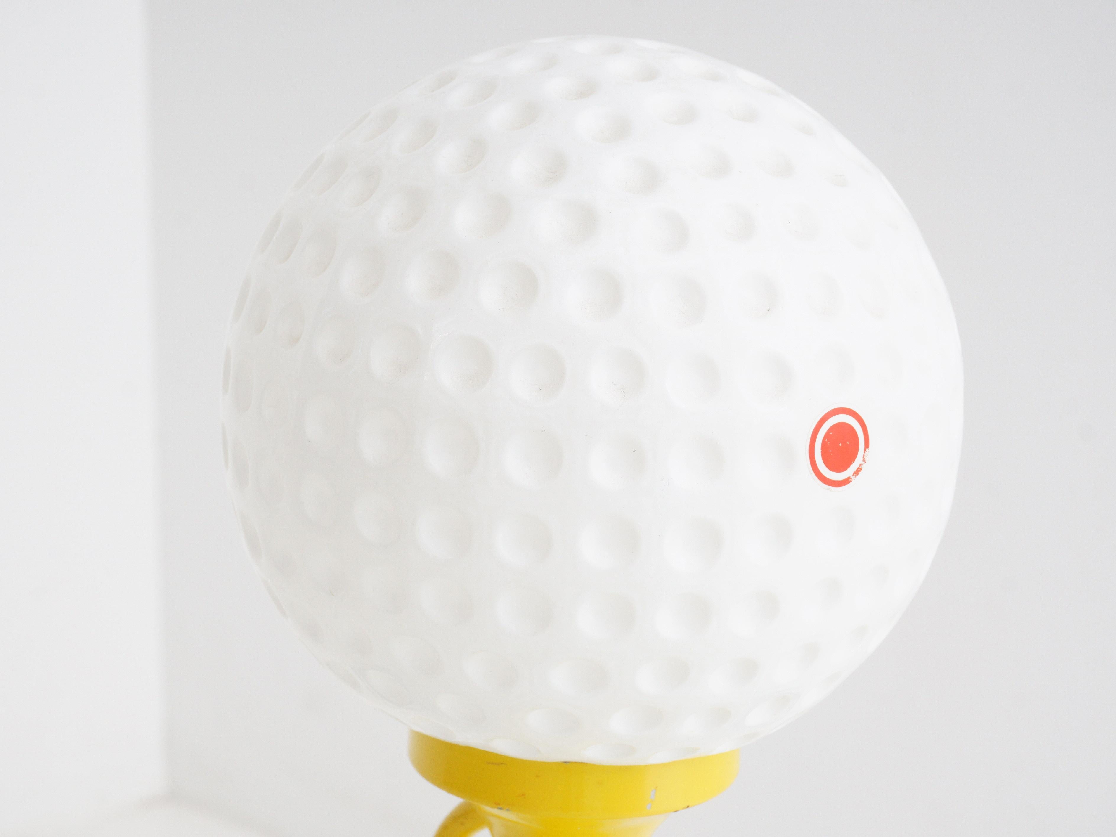 Tee off your décor with this lamp that's as stylish as your swing. With a golf ball-shaped shade perched on a tee, it's a bright idea that's par for the course.

- 16.5