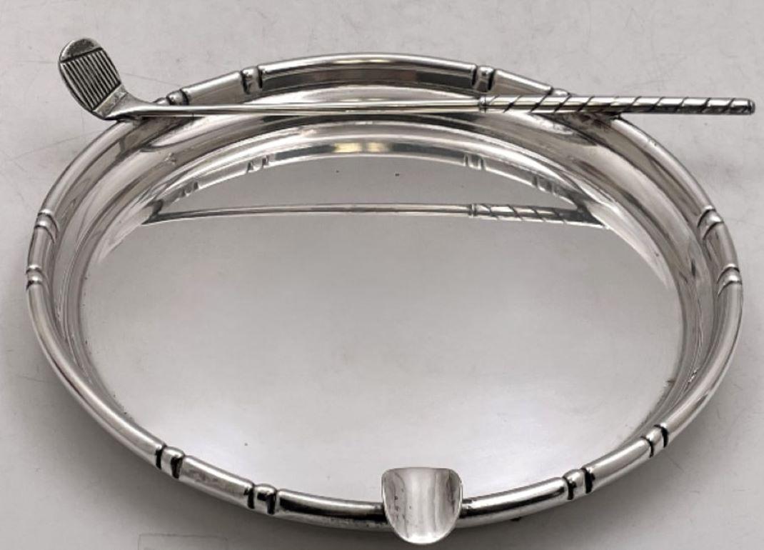 Sterling silver cigar ashtray, beautifully adorned with a realistic golf club. It measures 7'' in diameter (length of the club is 7 1/4'') by 1 1/3'' in height, weighs 6.6 troy ounces, and bears hallmarks as shown.

Please feel free to ask us any