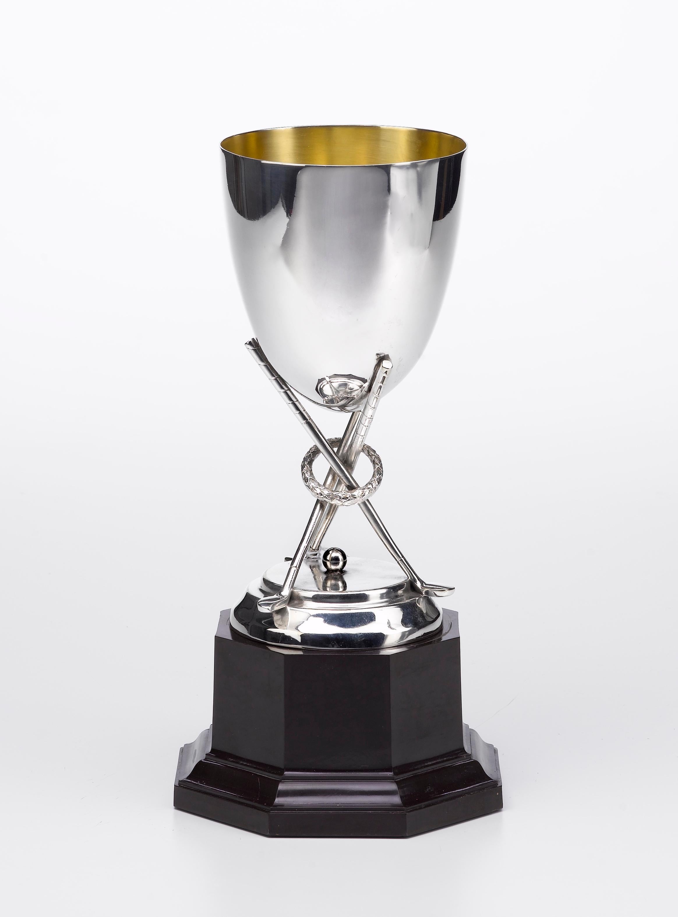 Offered is a unique, antique silver golf trophy. This sterling silver trophy was designed during the 19th century as an award for the winner of a golf competition. The trophy includes a large chalice resting on top of three golf clubs. The golf