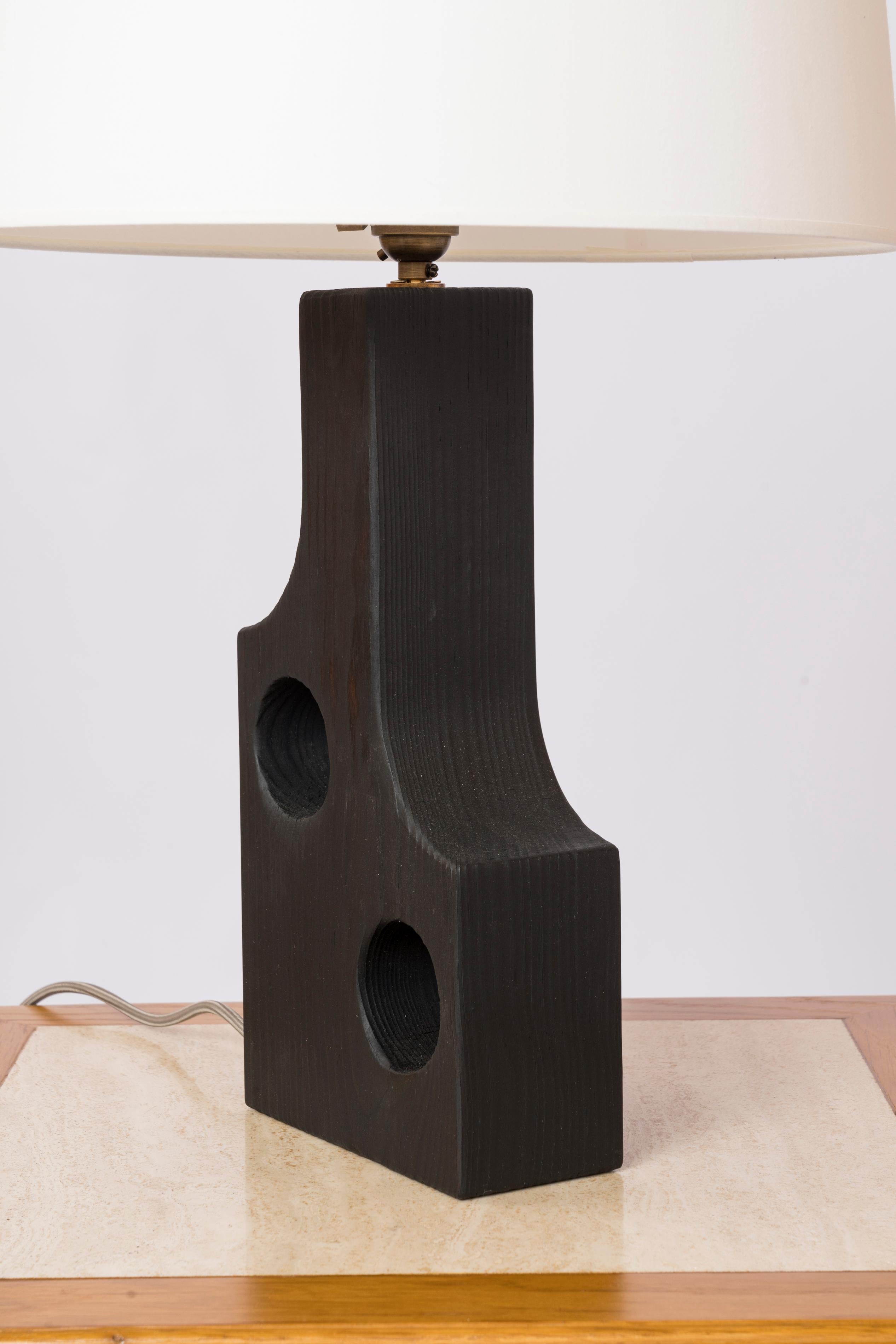 Lampe de bureau Shou Sugi Ban en pin calciné. Il a la forme d'une bouteille percée de deux grands trous sur chaque côté. Système électrique américain.
Design exclusif de Facto Atelier Paris.
Cette lampe est expédiée de France et peut être renvoyée