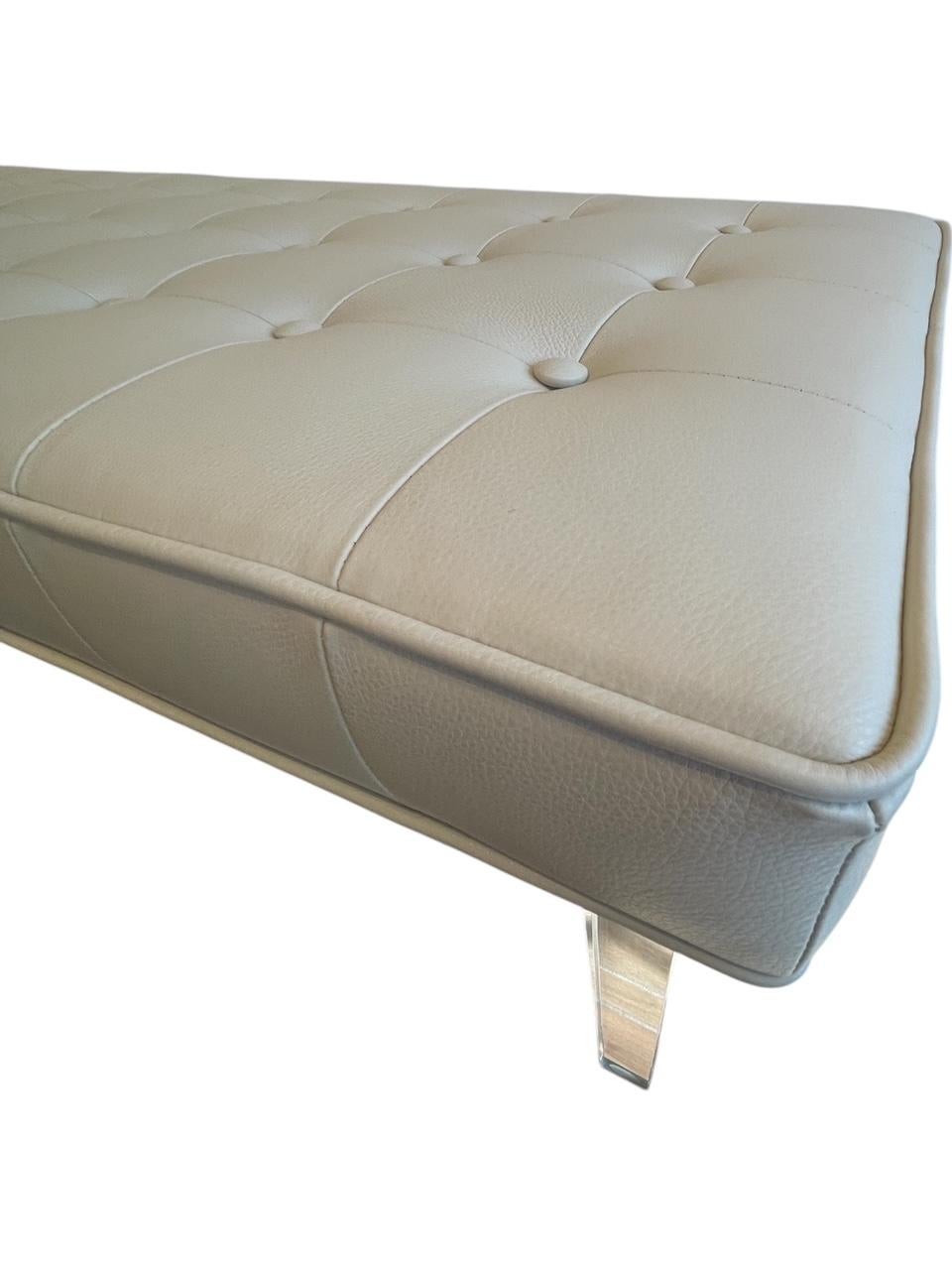 Il s'agit d'une pièce de design moderne et luxueux réalisée sur mesure par l'atelier Gomez. Avec des pieds en lucite et un insert en mousse de première qualité, cette banquette est fabriquée en cuir italien texturé de couleur parchemin. L'assise