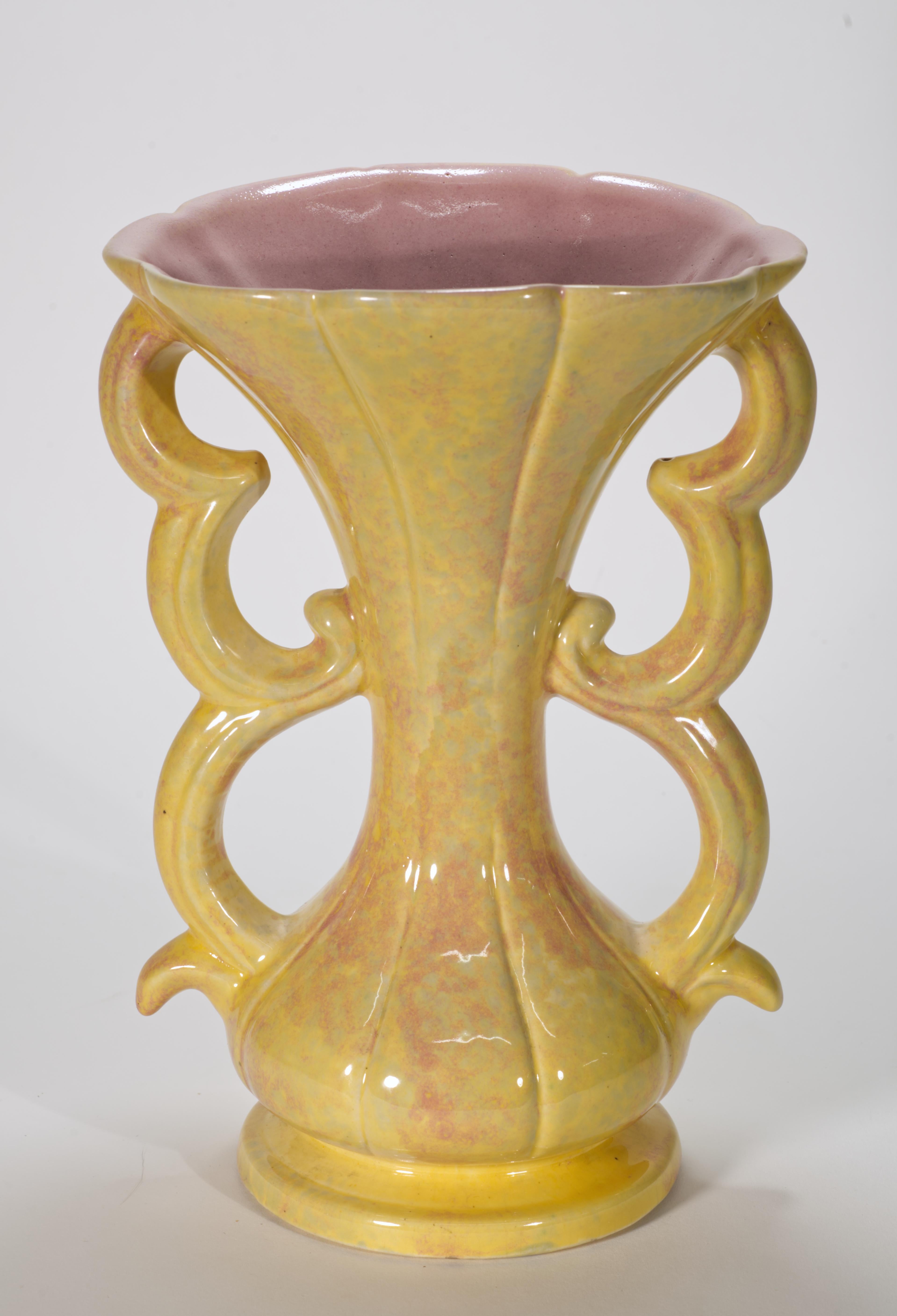  Vintage ceramic Art Deco style vase was made by Gonder Pottery in Zanesville, Ohio. The vase has highly sculptural shape with complex, graphic handles that is accentuated by drip glaze in soft, buttery yellow and light pink palette. The interior of