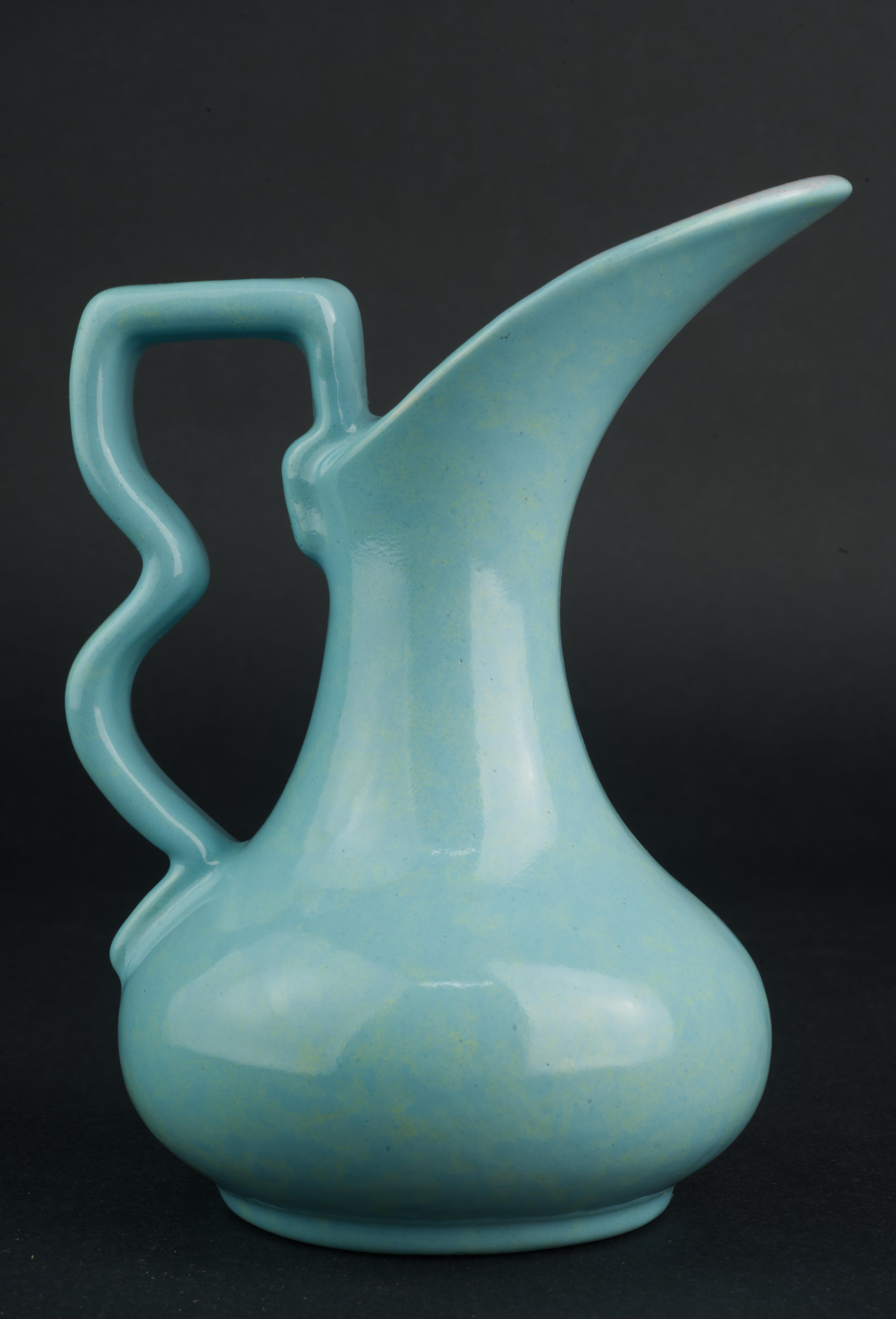  Vintage ceramic ewer-shaped bud vase was made by Gonder Pottery in Zanesville, Ohio. The vase has highly sculptural, characteristic mid-century modern shape with graphic handle that is accentuated by complex blue glaze with light drip glaze accent.