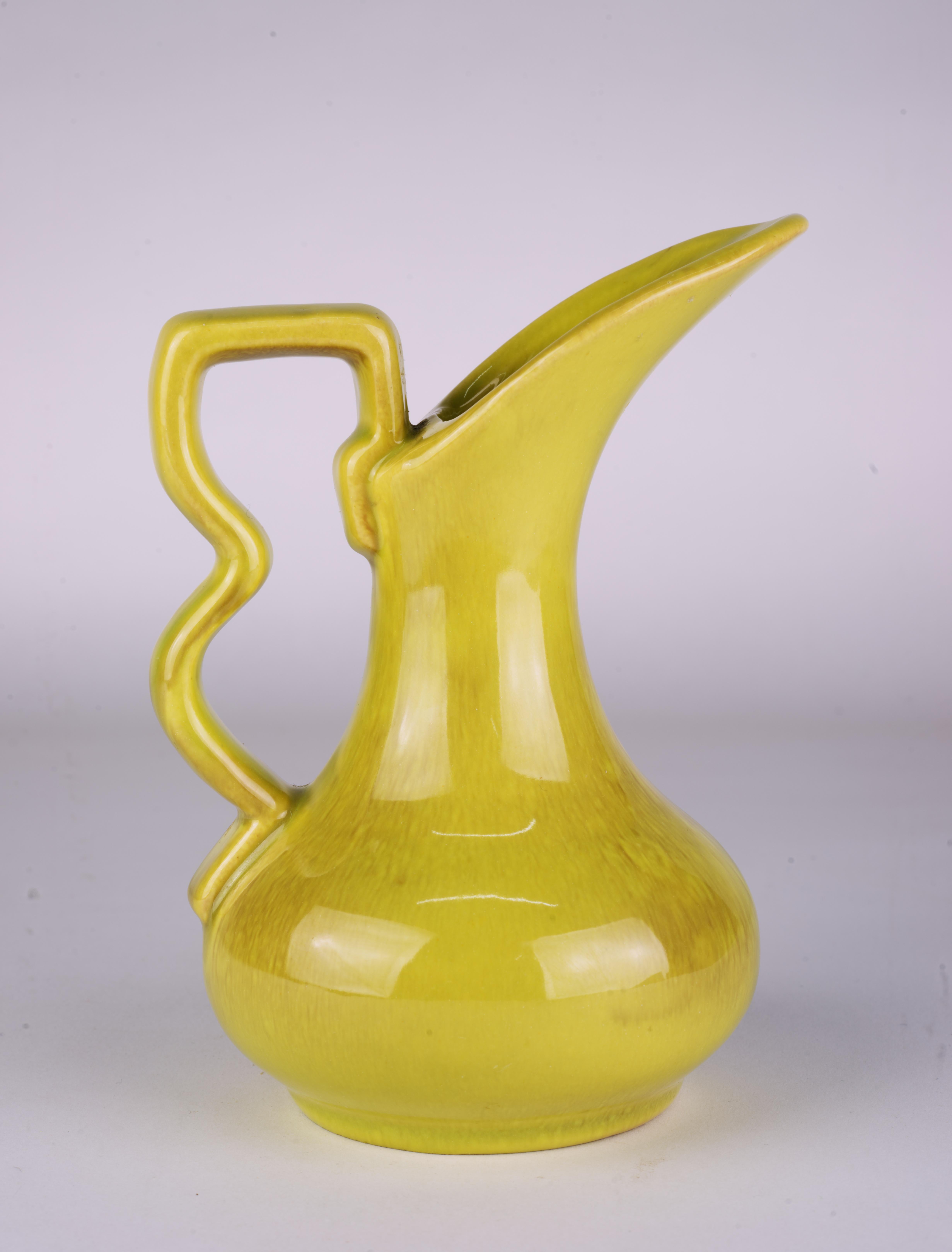 Vintage ceramic ewer-shaped bud vase was made by Gonder Pottery in Zanesville, Ohio. The vase has highly sculptural, characteristic mid-century modern shape with graphic handle that is accentuated by complex chartreuse glaze with light brown drip