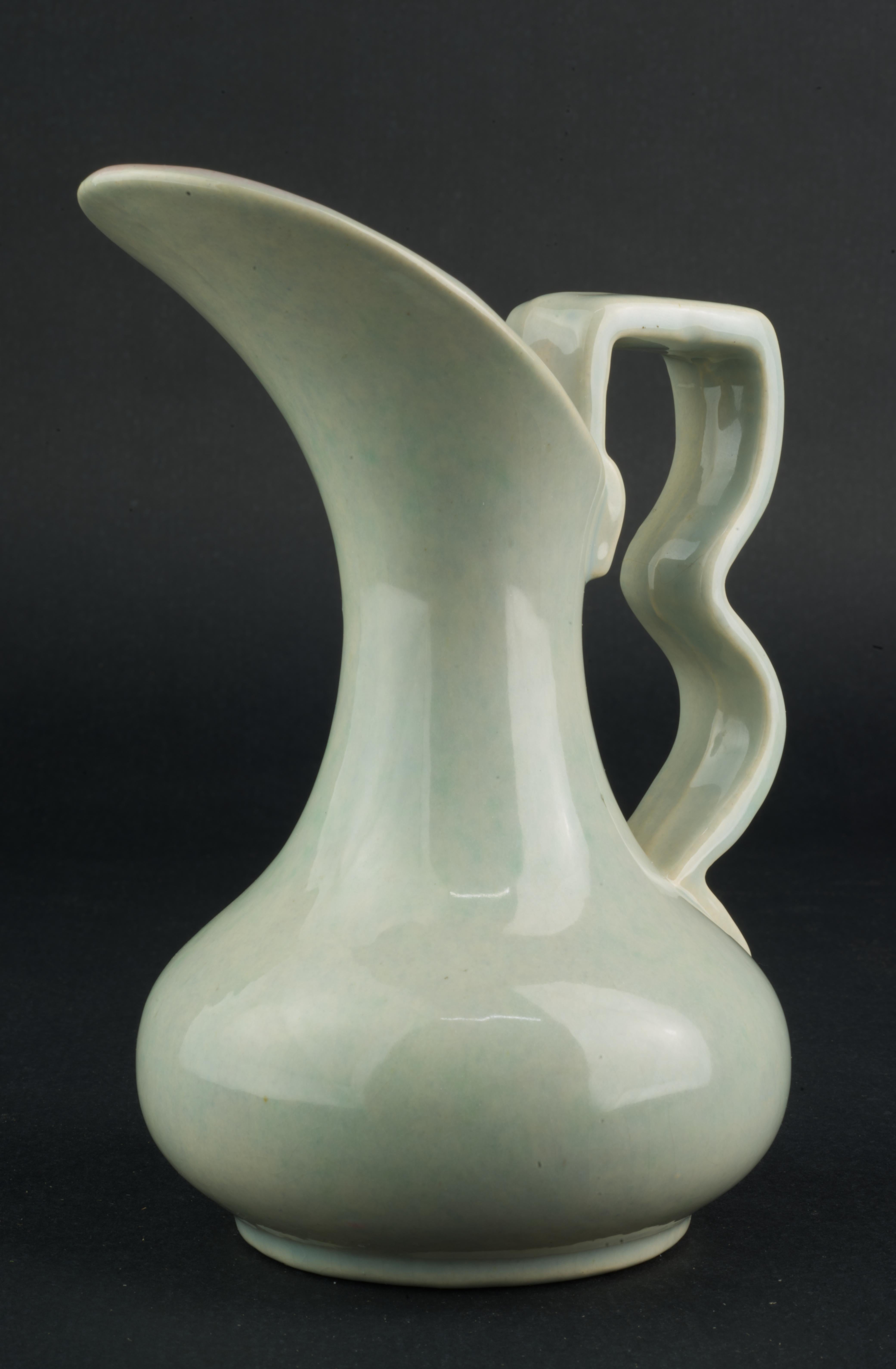   Ce vase à bourgeons en forme d'aiguière en céramique vintage a été fabriqué par Gonder Pottery à Zanesville, Ohio. Le vase a une forme très sculpturale, caractéristique de la modernité du milieu du siècle, avec une poignée graphique, accentuée par