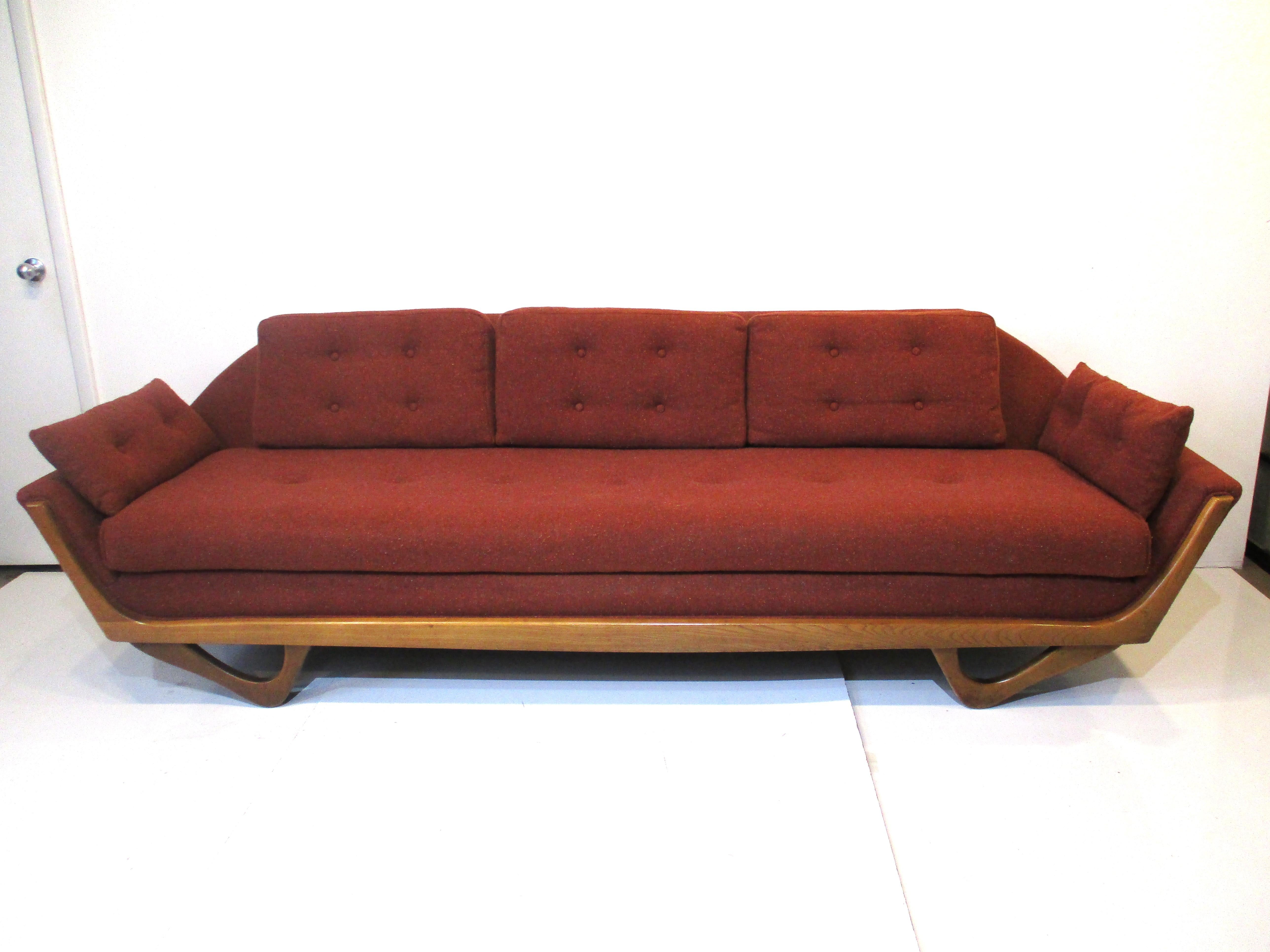 A midcentury upholstered Gondola sofa with loose back and arm cushions in the manner of Adrian Pearsall. A very comfortable and well crafted piece in a speckled toned fabric with bits of lighter tones of blue , orange , tan on a brick colored