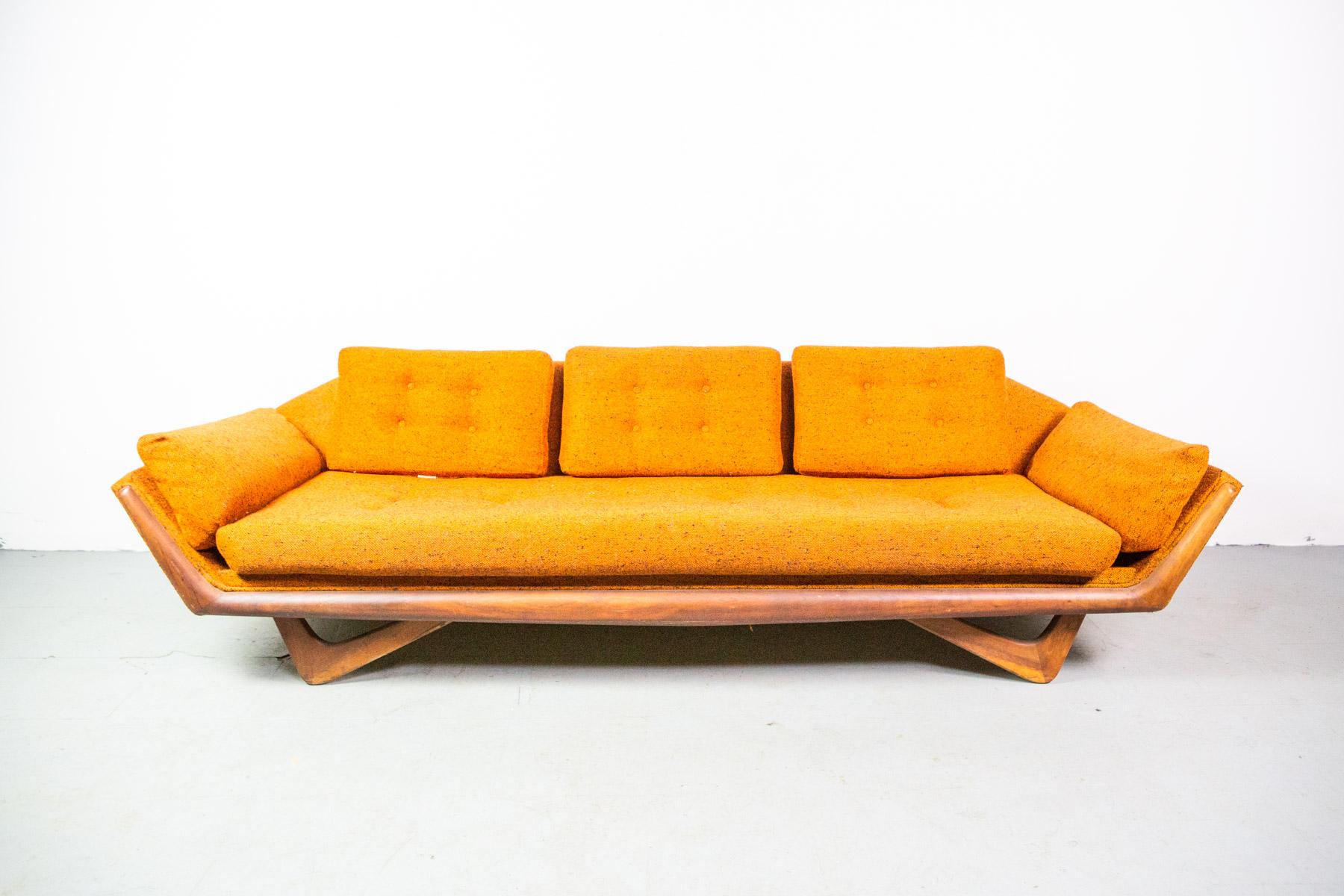 This beautiful vintage modern sofa features the innovative design of midcentury great Adrian Pearsall. Sculpted wood legs and frame paired with vintage fabric and cutaway seat back all add to the appeal of this uniquely shaped 