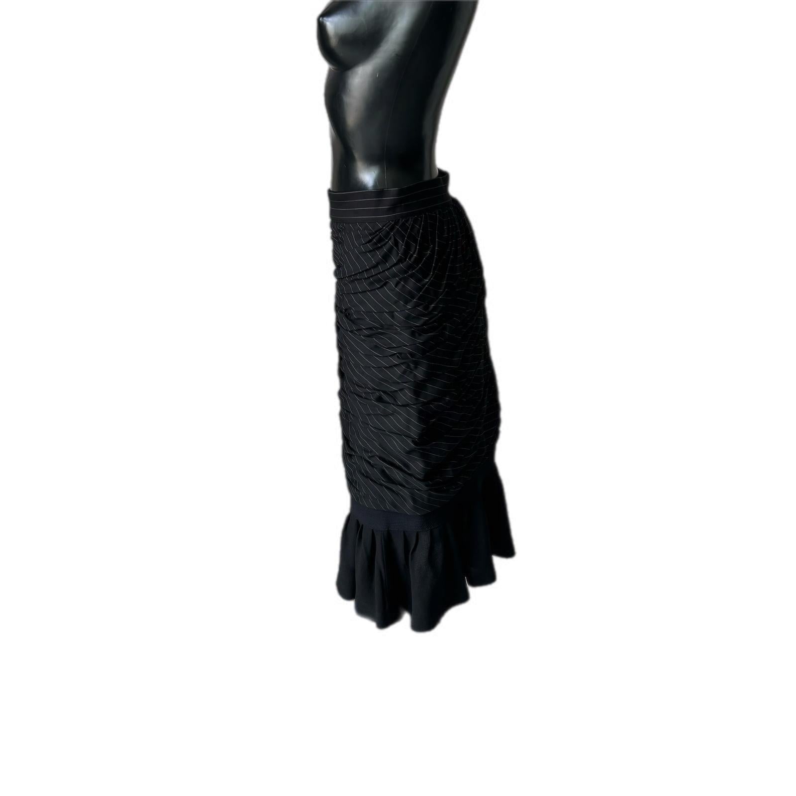 Jupe à rayures noires et blanches de Gianni Versace  avec drapé latéral et voulantant vert doux en dessous  de manière à ne faire ressortir la couleur qu'avec le mouvement du corps.
Fermeture sur le côté, vêtement vintage haute couture en 
