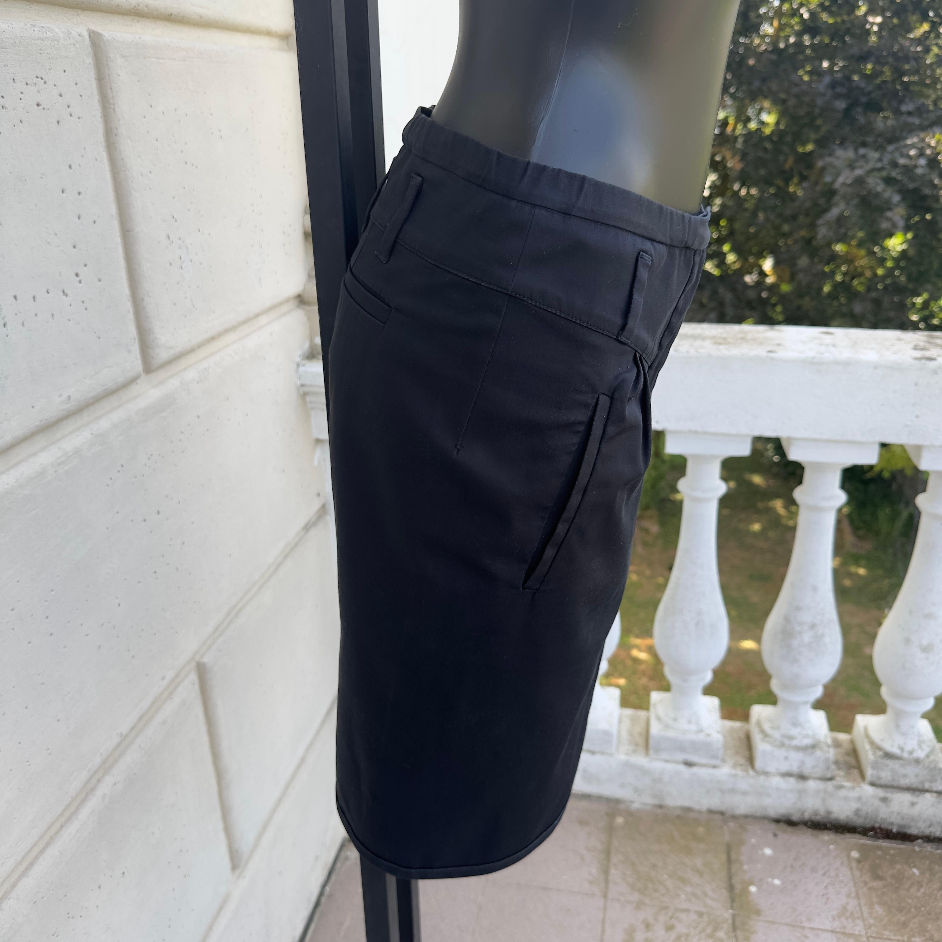 Jupe de mode Miu Miu noire comme neuve avec plis sur le devant et poches sur les côtés et au dos. Bordure en tissu contrastant
Étiquette de composition enlevée 
Mesures :
Taille 38cm
Hanches 44cm
Longueur 48cm